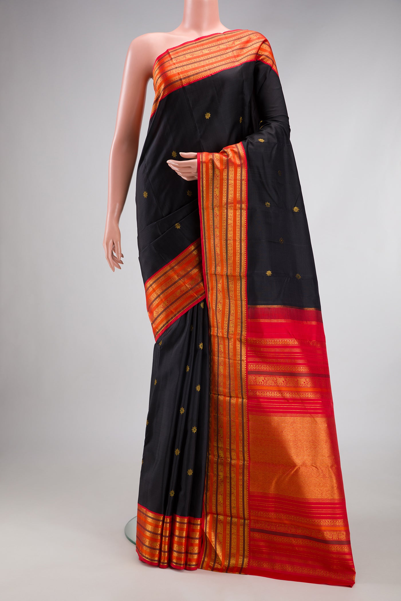 Black Kanjivaram Silk Saree with Zari Butta on the body and Zari Border.  displayed on a mannequin