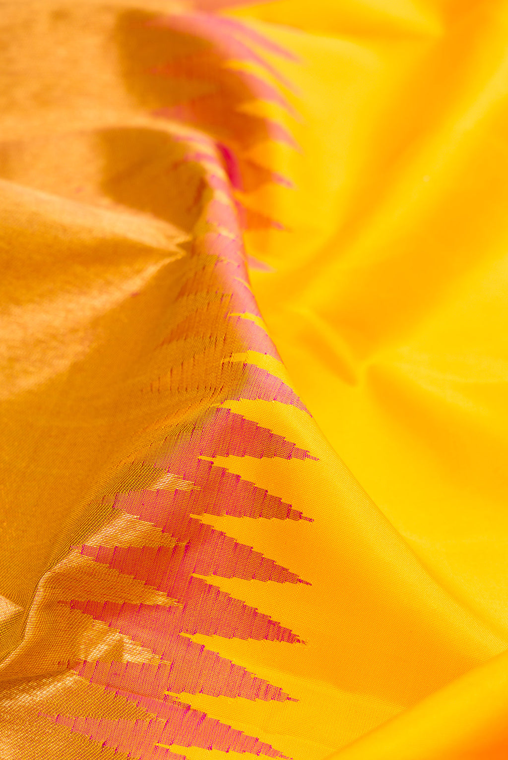 Close up of Yellow Kanjivaram Silk Saree with Plain Body and Rising Temple Border.  displaying folds