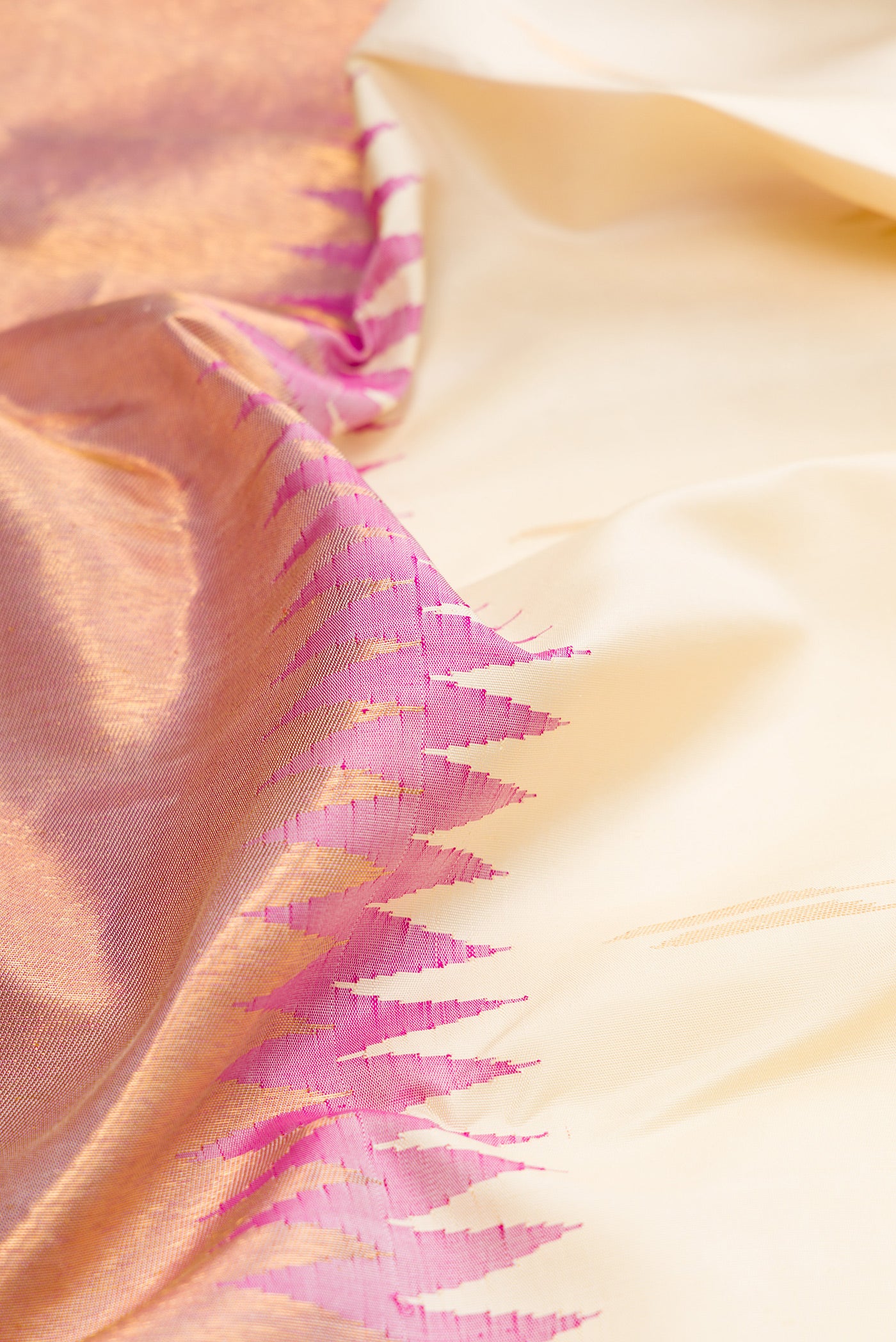 Close up of Off White Kanjivaram Silk Saree with Zari Butta on the body and Rising Temple Border.  displaying folds