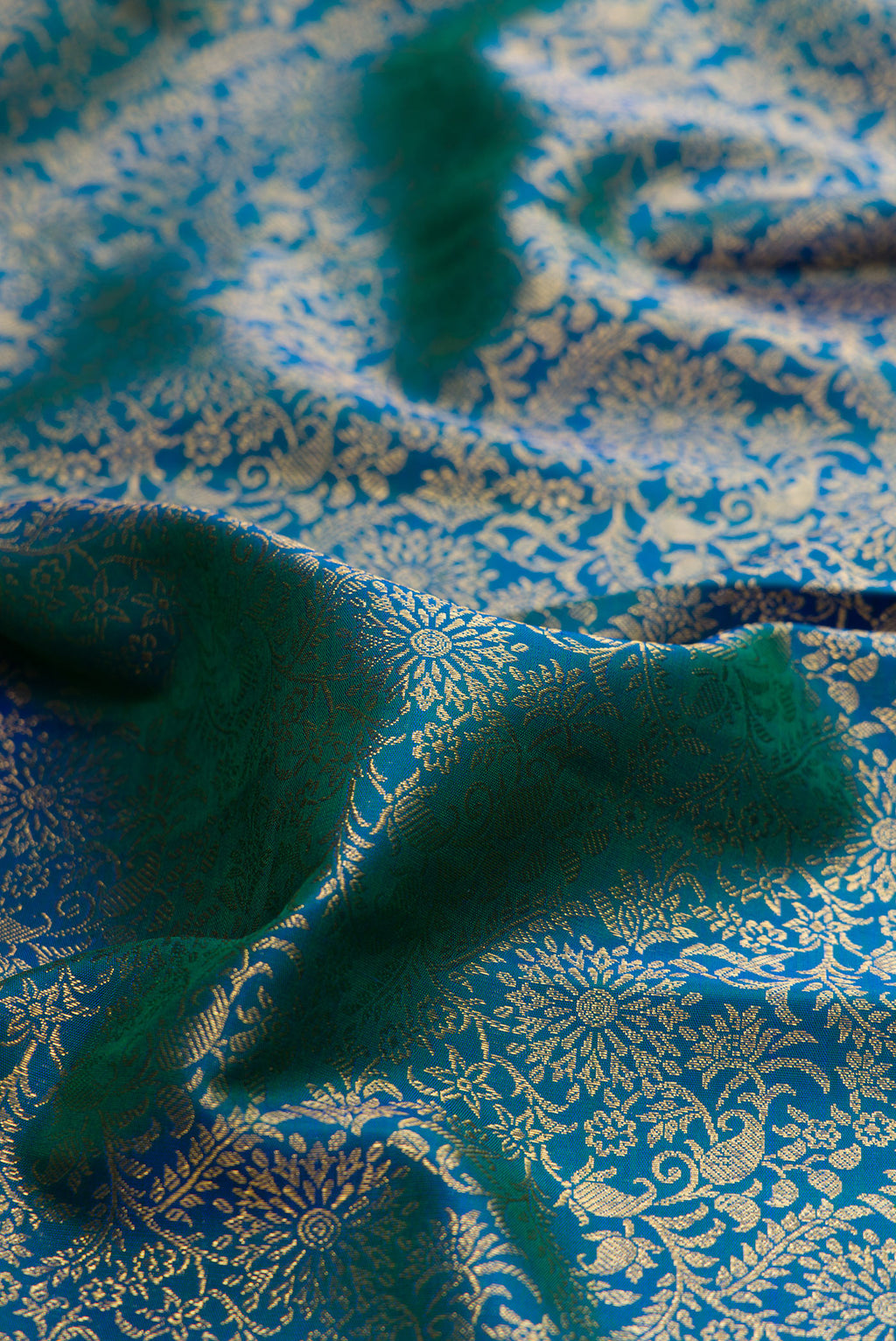Close up of Pure Silk Peacock Blue Kanchipuram Saree with Zari Brocade on the body and Zari Border.  displaying folds