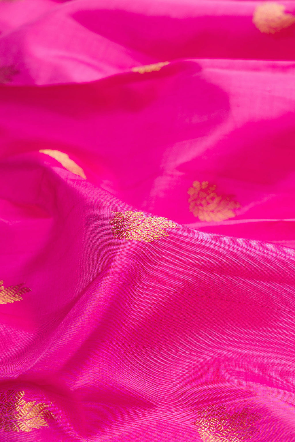 Close up of Pure Silk Rose pink Kanchipuram Saree with Zari Butta on the body and Zari Border.  displaying folds