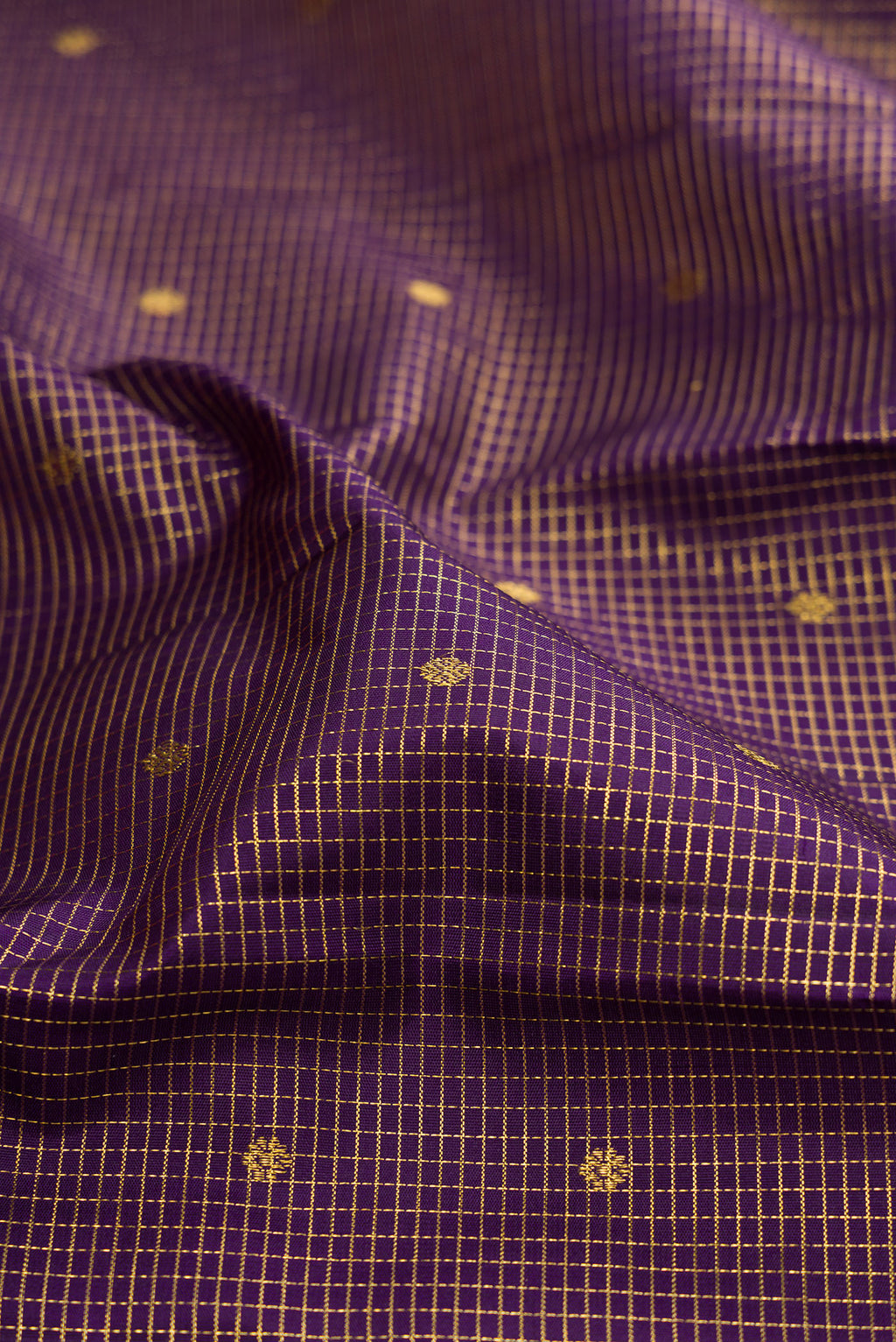 Close up of Purple Kanjivaram Silk Saree with Checked design on the body and Zari Border.  displaying folds