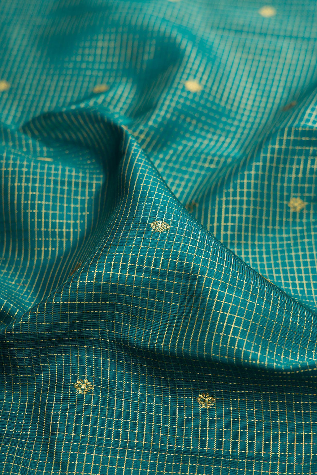 Close up of Green Kanjivaram Silk Saree with Checked design on the body and Zari Border.  displaying folds