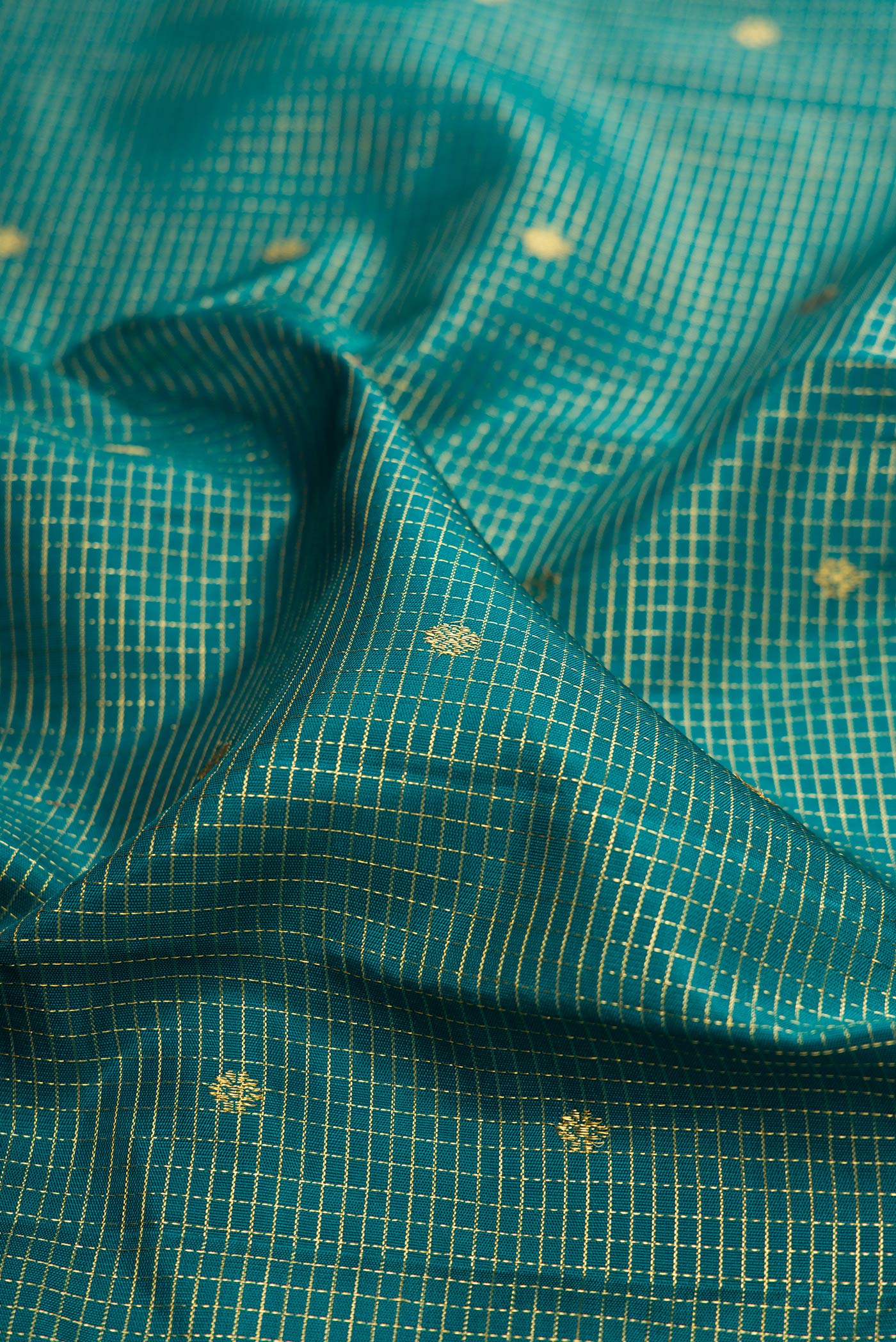 Close up of Green Kanjivaram Silk Saree with Checked design on the body and Zari Border.  displaying folds