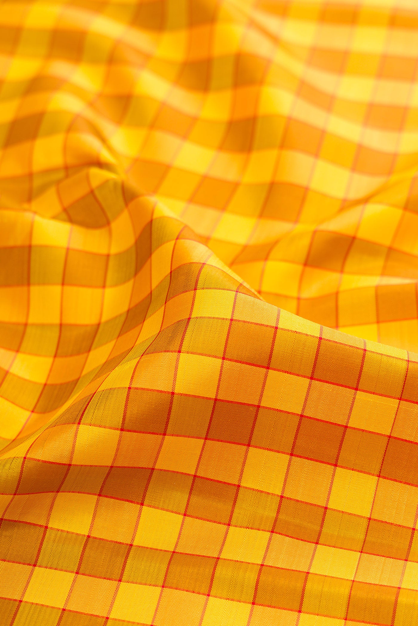 Close up of Yellow Kanjivaram Silk Saree with Checked design on the body and Zari Border.  displaying folds
