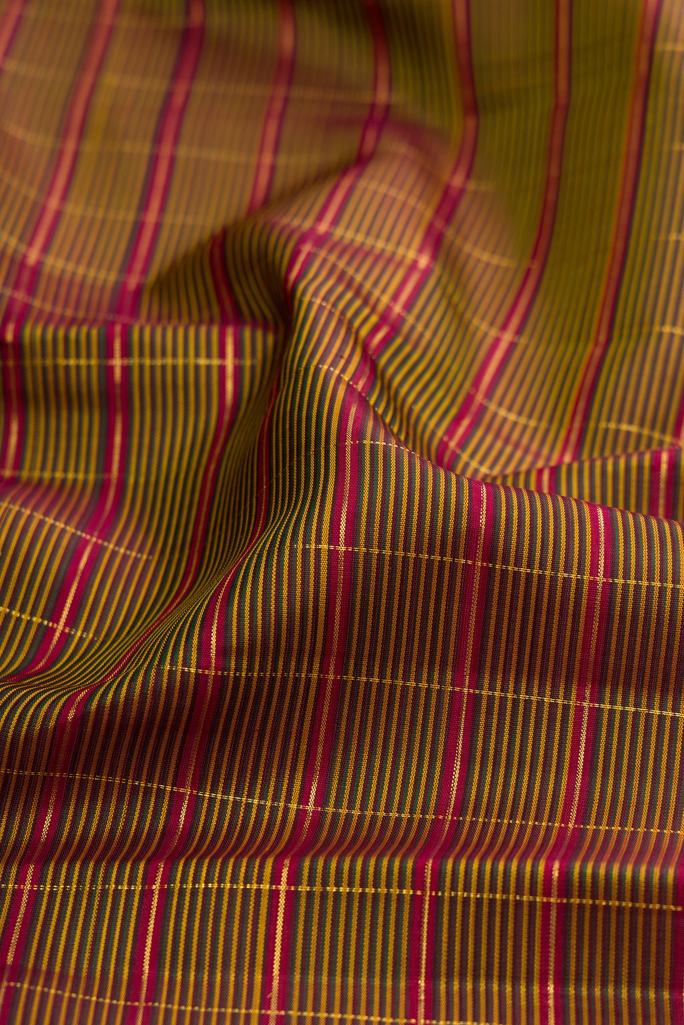 Close up of Mehandi Green Kanchipuram Silk Saree with Checked design on the body and Zari Border.  displaying folds