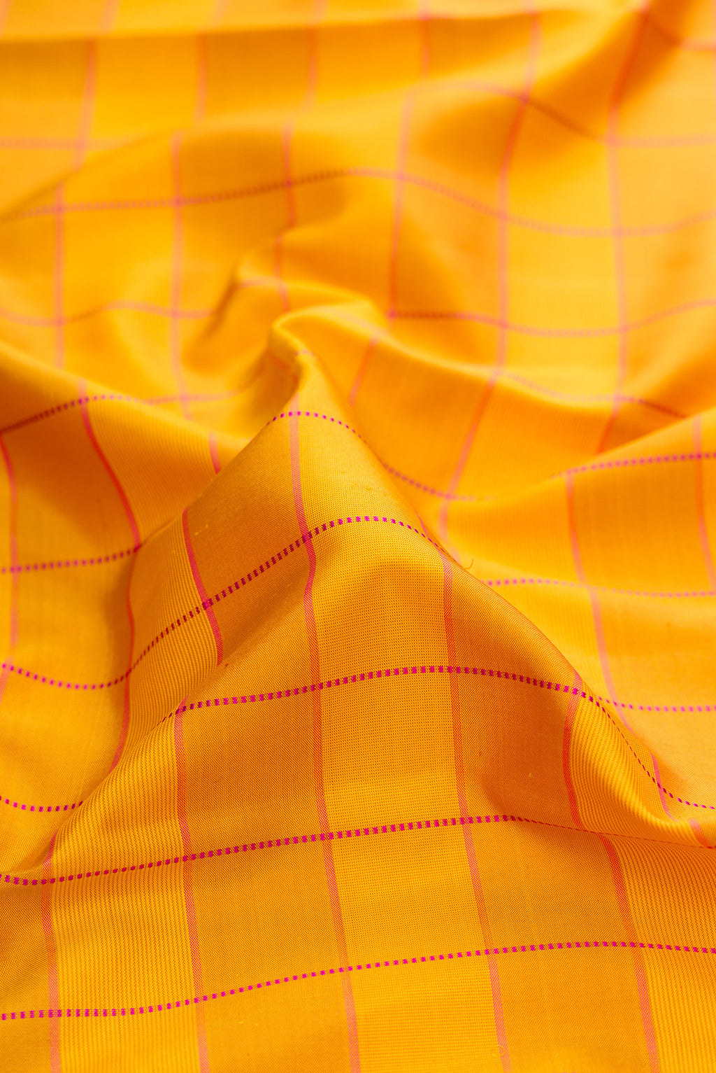 Close up of Pure Silk Mustard Kanchipuram Saree with Checked design on the body and Thin Zari Line.  displaying folds