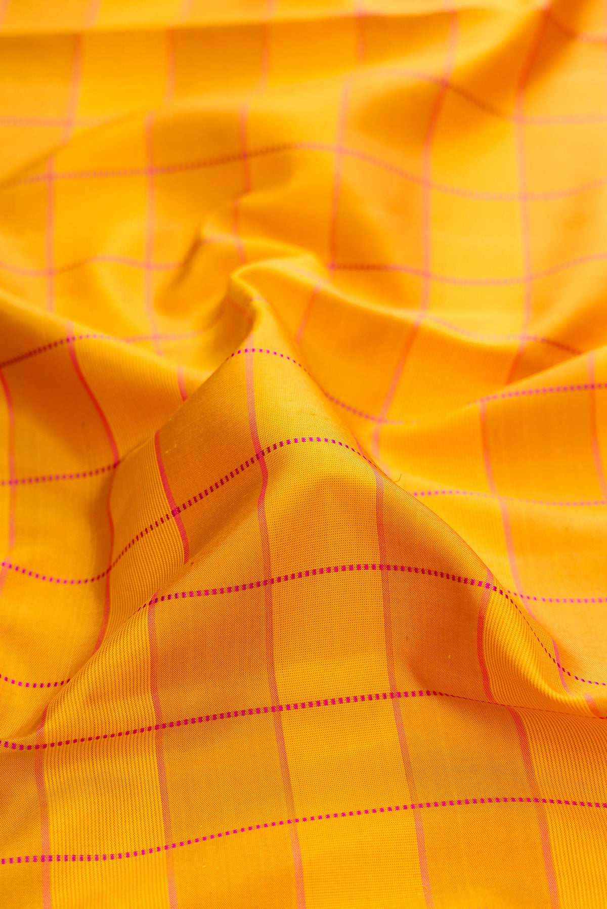 Close up of Pure Silk Mustard Kanchipuram Saree with Checked design on the body and Thin Zari Line.  displaying folds