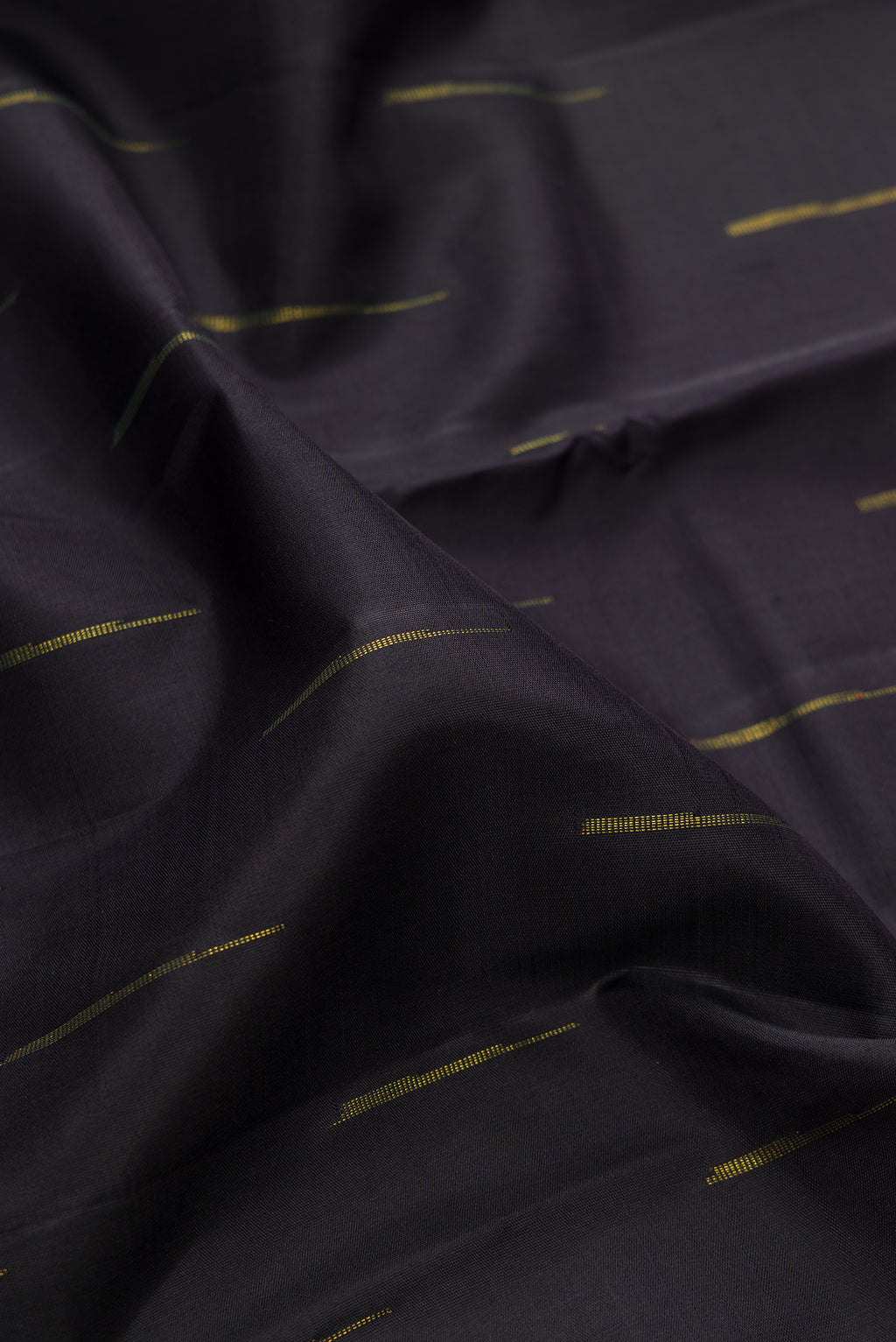 Close up of Black Kanchipuram Silk Saree with Zari Butta on the body and Ganga Jamuna Border.  displaying folds