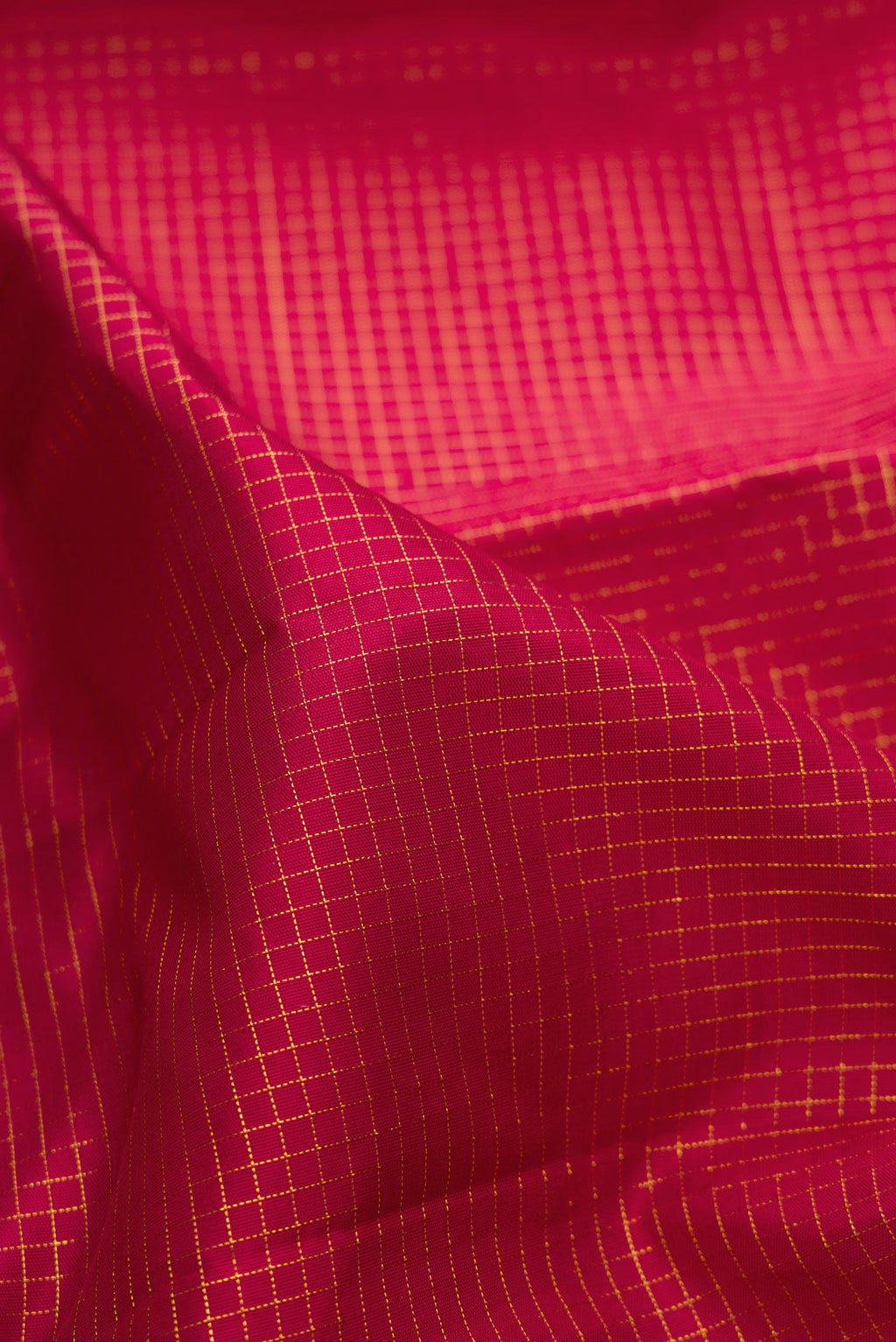 Close up of Maroon Kanchipuram Silk Saree with Checked design on the body and Zari Border.  displaying folds