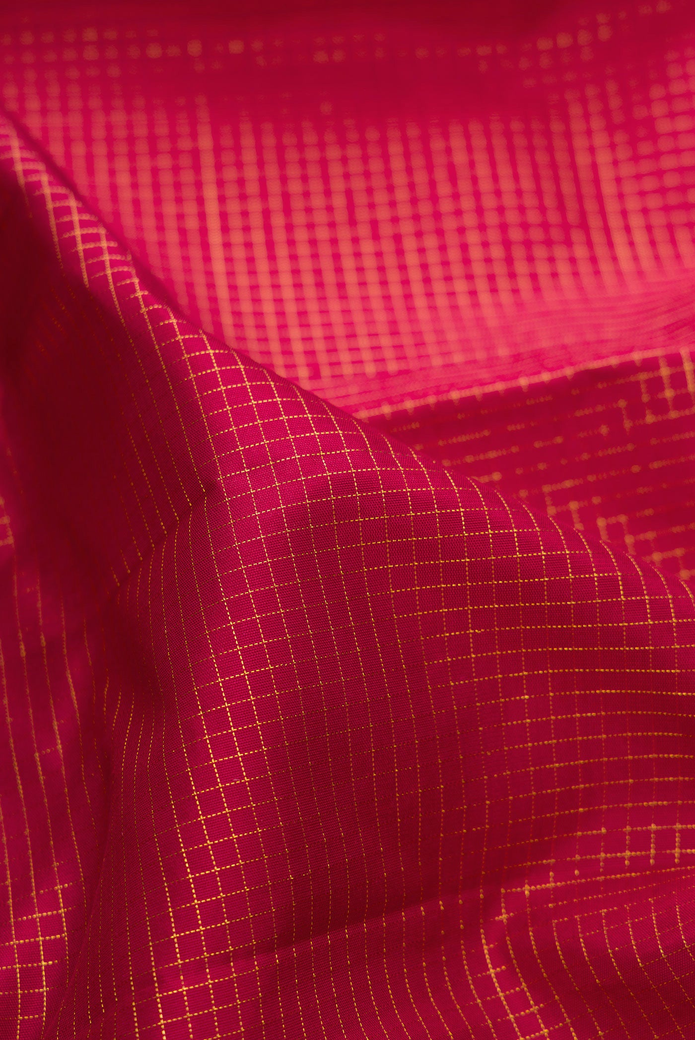 Close up of Maroon Kanchipuram Silk Saree with Checked design on the body and Zari Border.  displaying folds