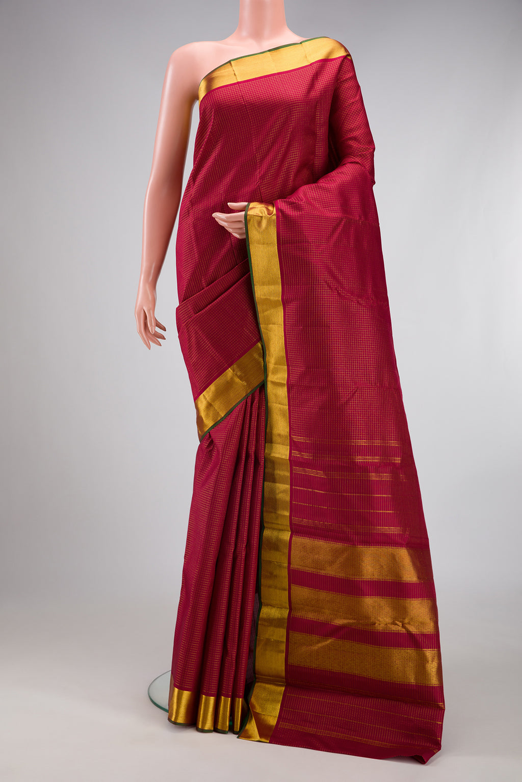 Maroon Kanchipuram Silk Saree with Checked design on the body and Zari Border.  displayed on a mannequin
