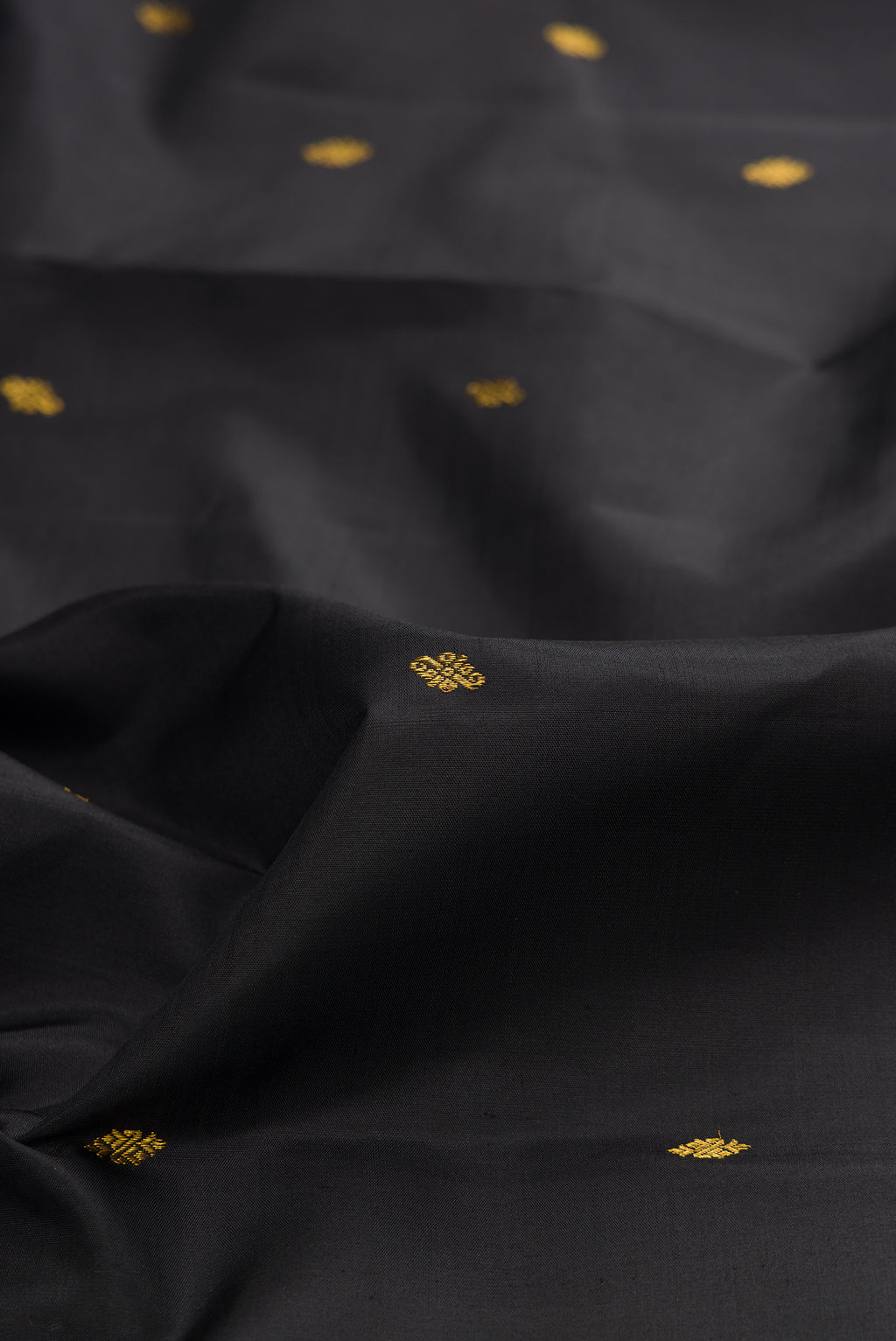 Close up of Black Kanjivaram Silk Saree with Zari Butta on the body and Zari Border.  displaying folds