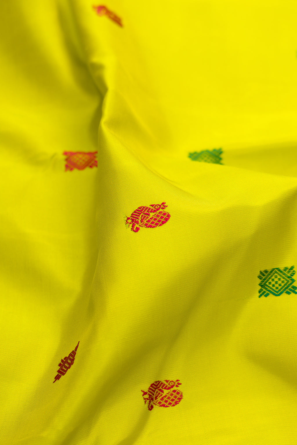 Close up of Parrot Green Kanjivaram Silk Saree with Thread Butta on the body and Zari Border.  displaying folds