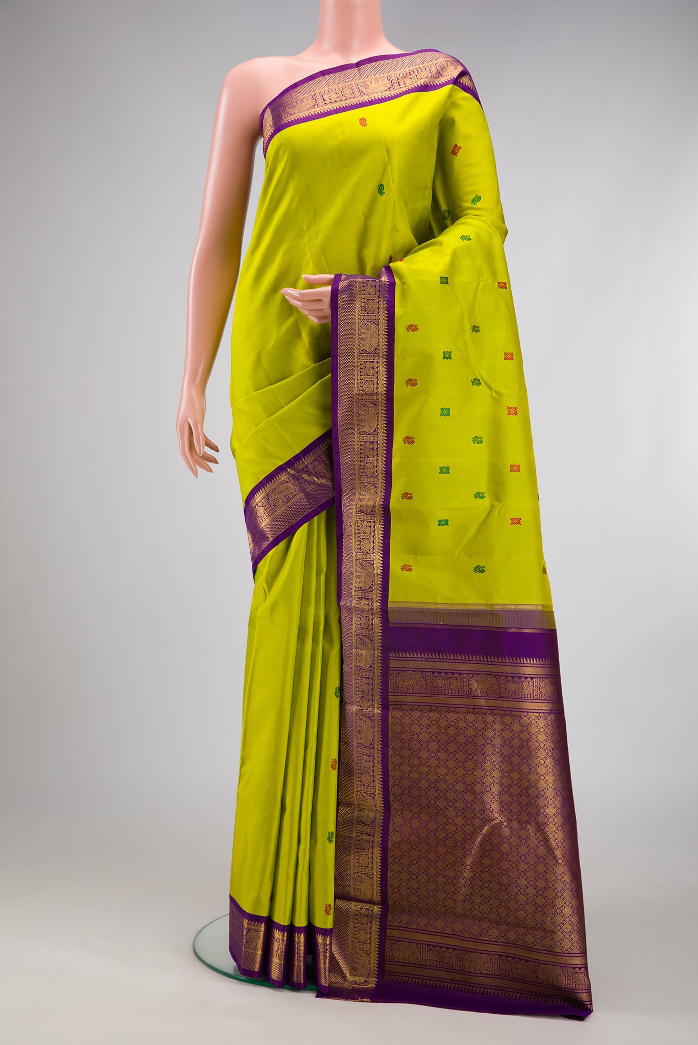Parrot Green Kanjivaram Silk Saree with Thread Butta on the body and Zari Border.  displayed on a mannequin