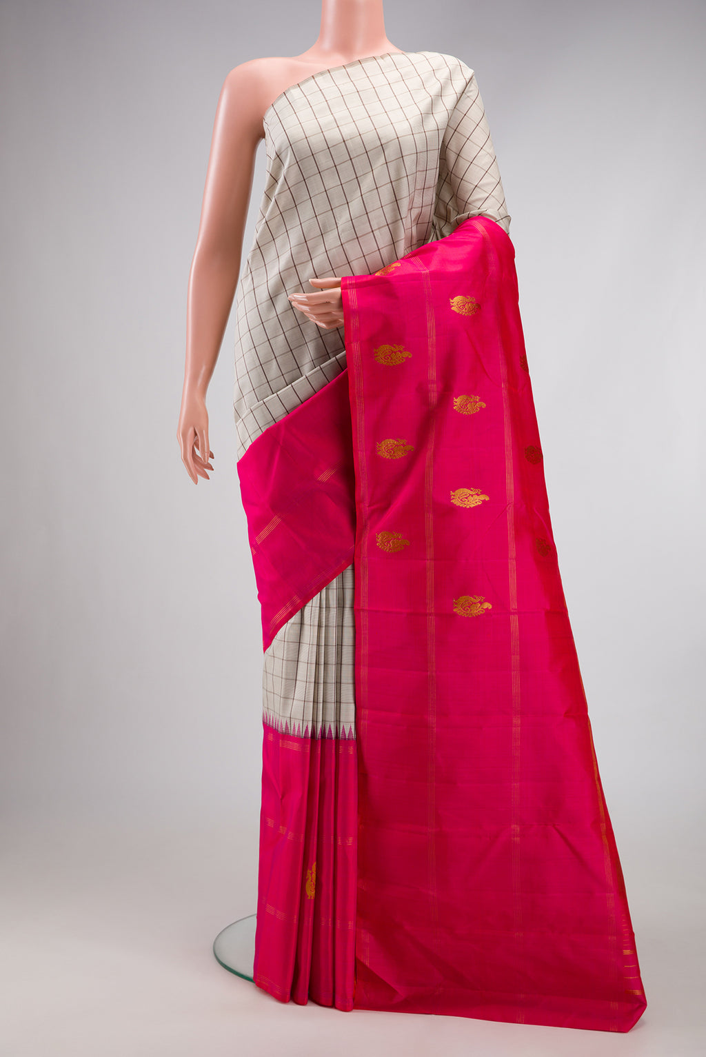 Beige Kanjivaram Silk Saree with Checked design on the body and Fancy Border.  displayed on a mannequin