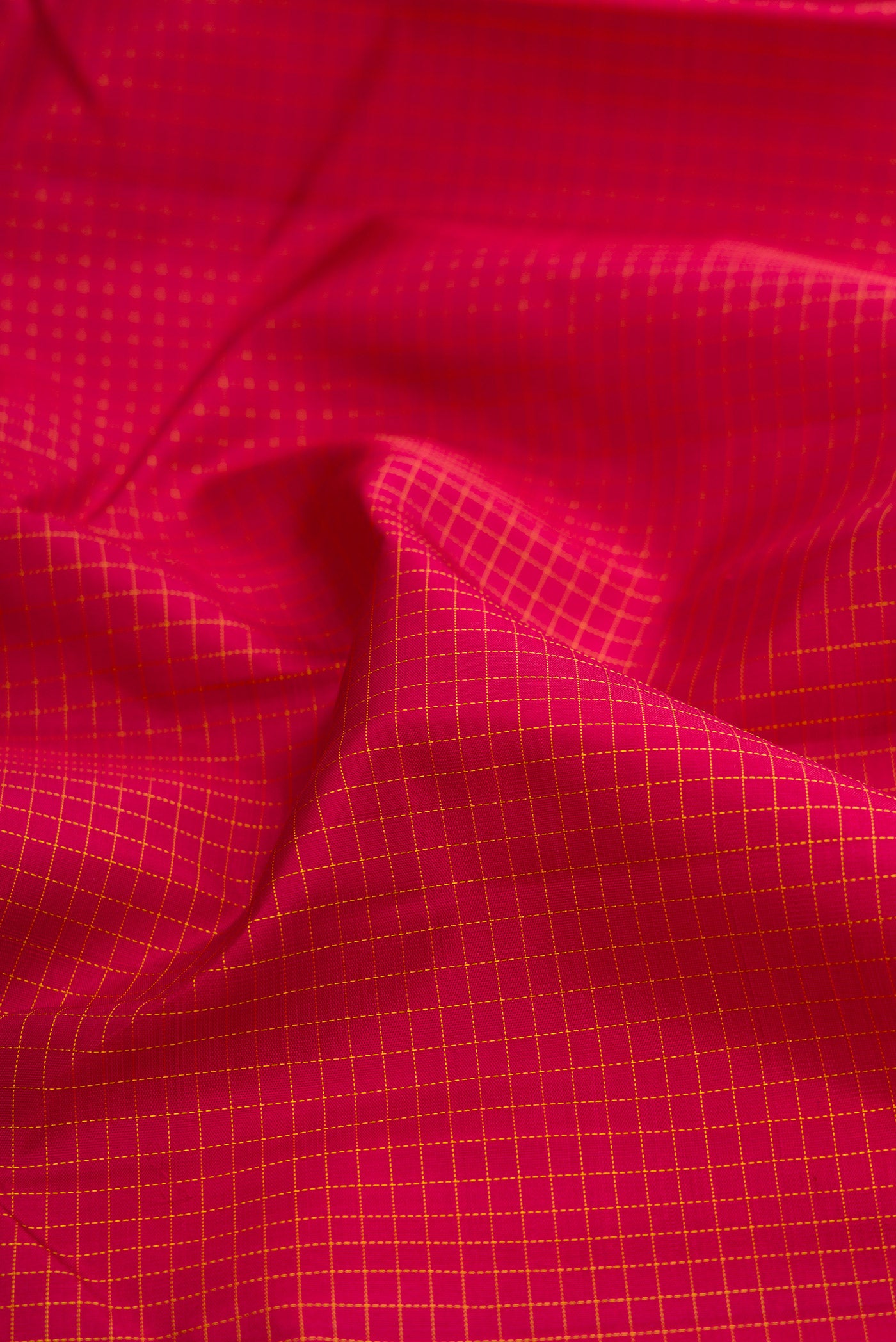 Close up of Maroon Kanchipuram Silk Saree with Checked design on the body and Zari Border.  displaying folds