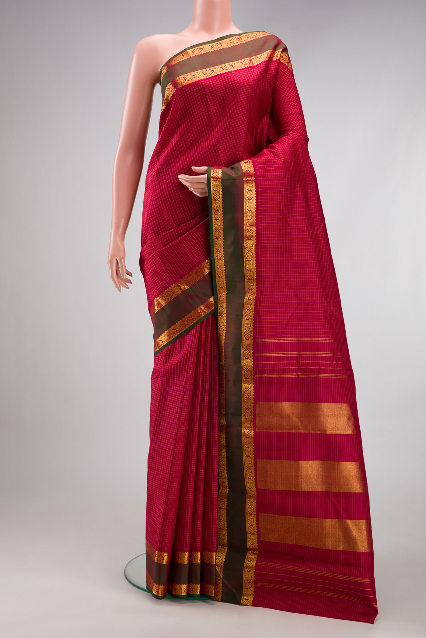 Maroon Kanchipuram Silk Saree with Checked design on the body and Zari Border.  displayed on a mannequin