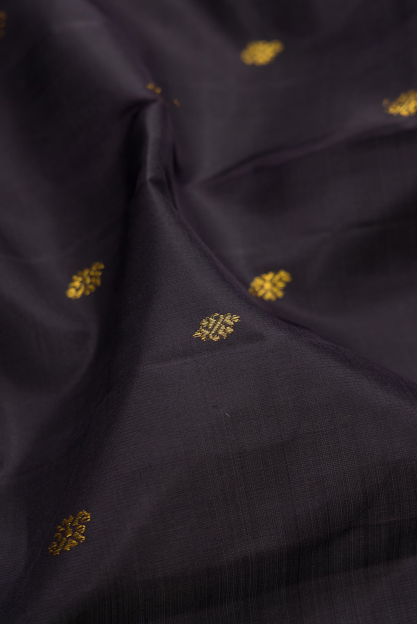 Close up of Black Kanjivaram Silk Saree with Zari Butta on the body and Zari Border.  displaying folds