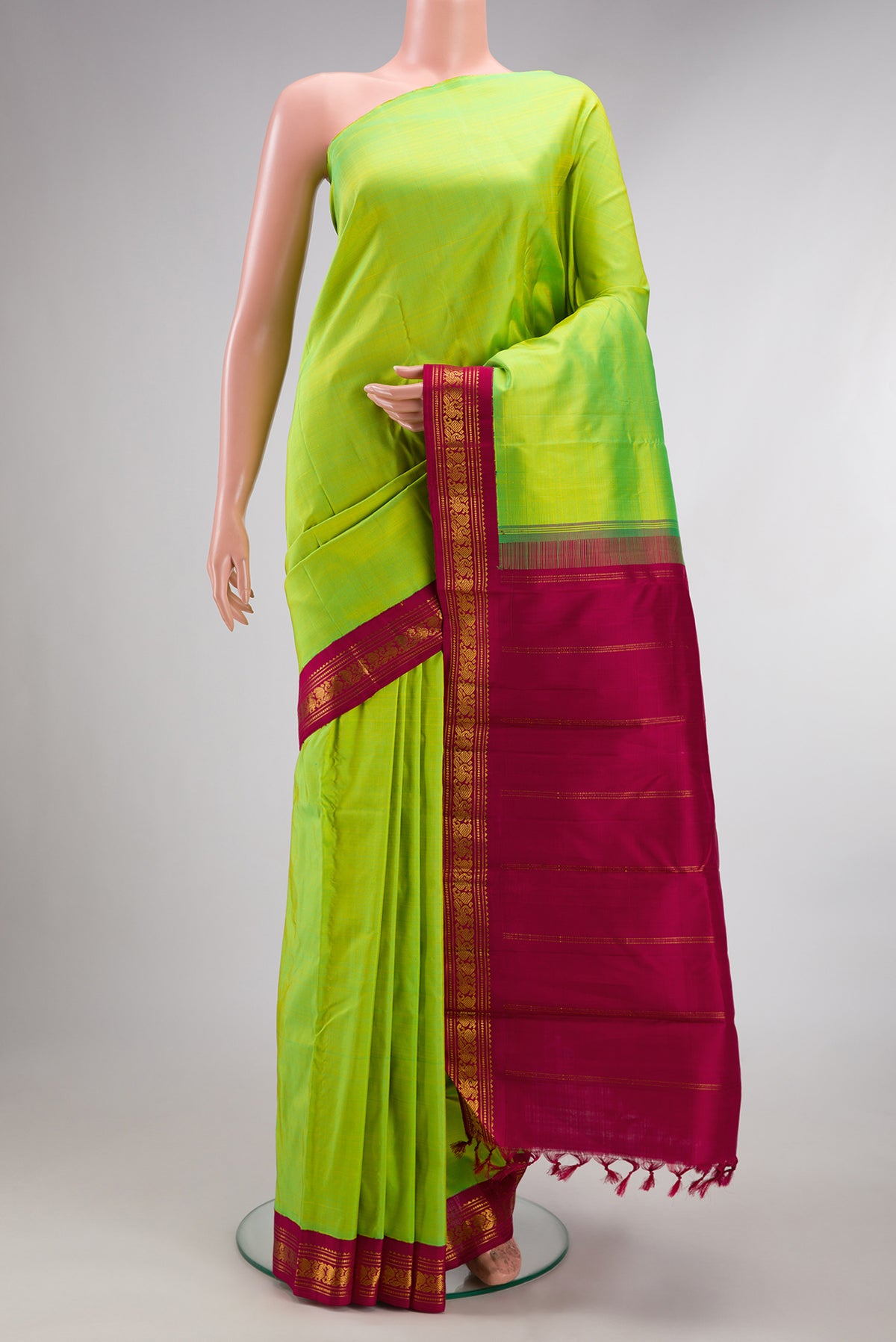Pure Silk Pure Zari Parrot Green Kanjivaram Saree with Plain Body and One Side Border.  displayed on a mannequin