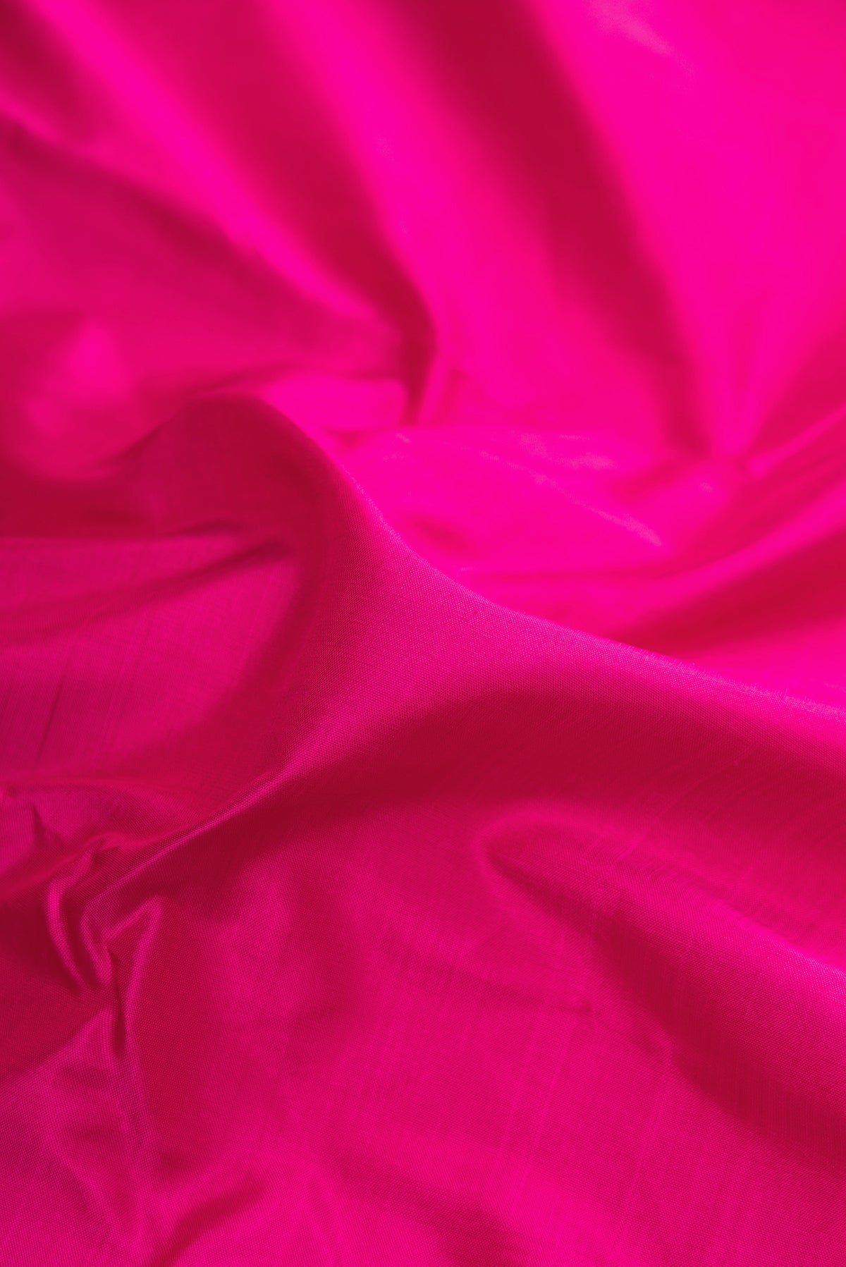 Close up of Pure Silk Pure Zari Dark Pink Kanjivaram Saree with Plain Body and One Side Border.  displaying folds