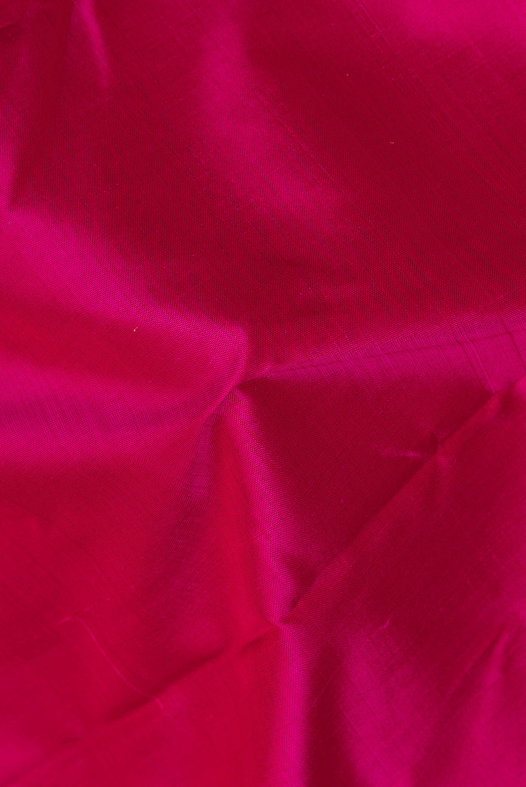 Close up of Pure Silk Pure Zari Dark Pink Kanjivaram Saree with Plain Body and One Side Border.  displaying folds