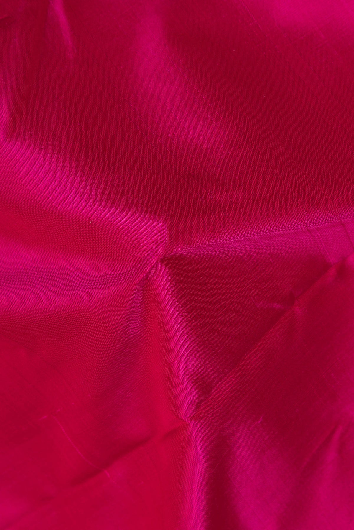 Close up of Pure Silk Pure Zari Dark Pink Kanjivaram Saree with Plain Body and One Side Border.  displaying folds