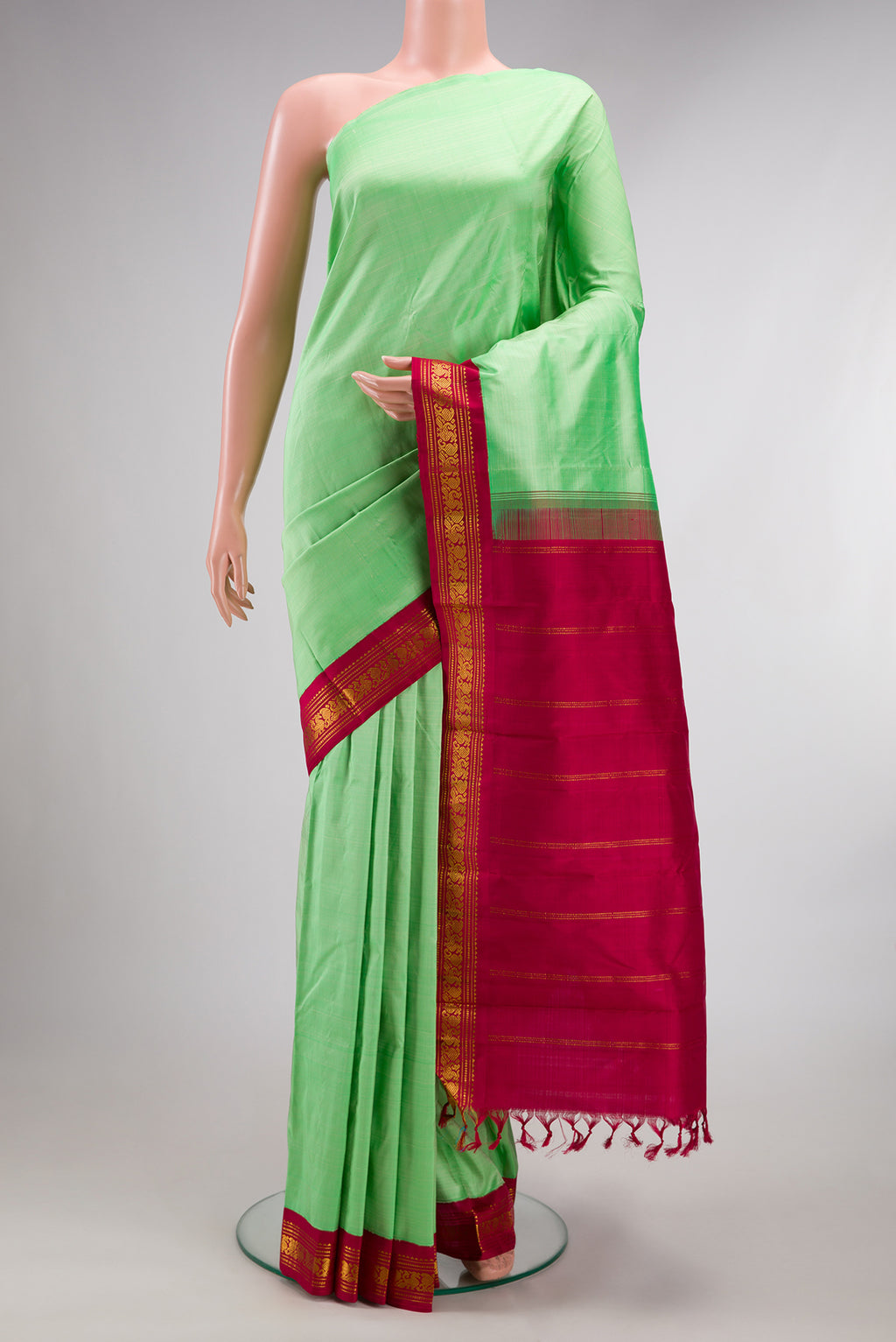 Pure Silk Pure Zari Pista Green Kanjivaram Saree with Plain Body and One Side Border.  displayed on a mannequin