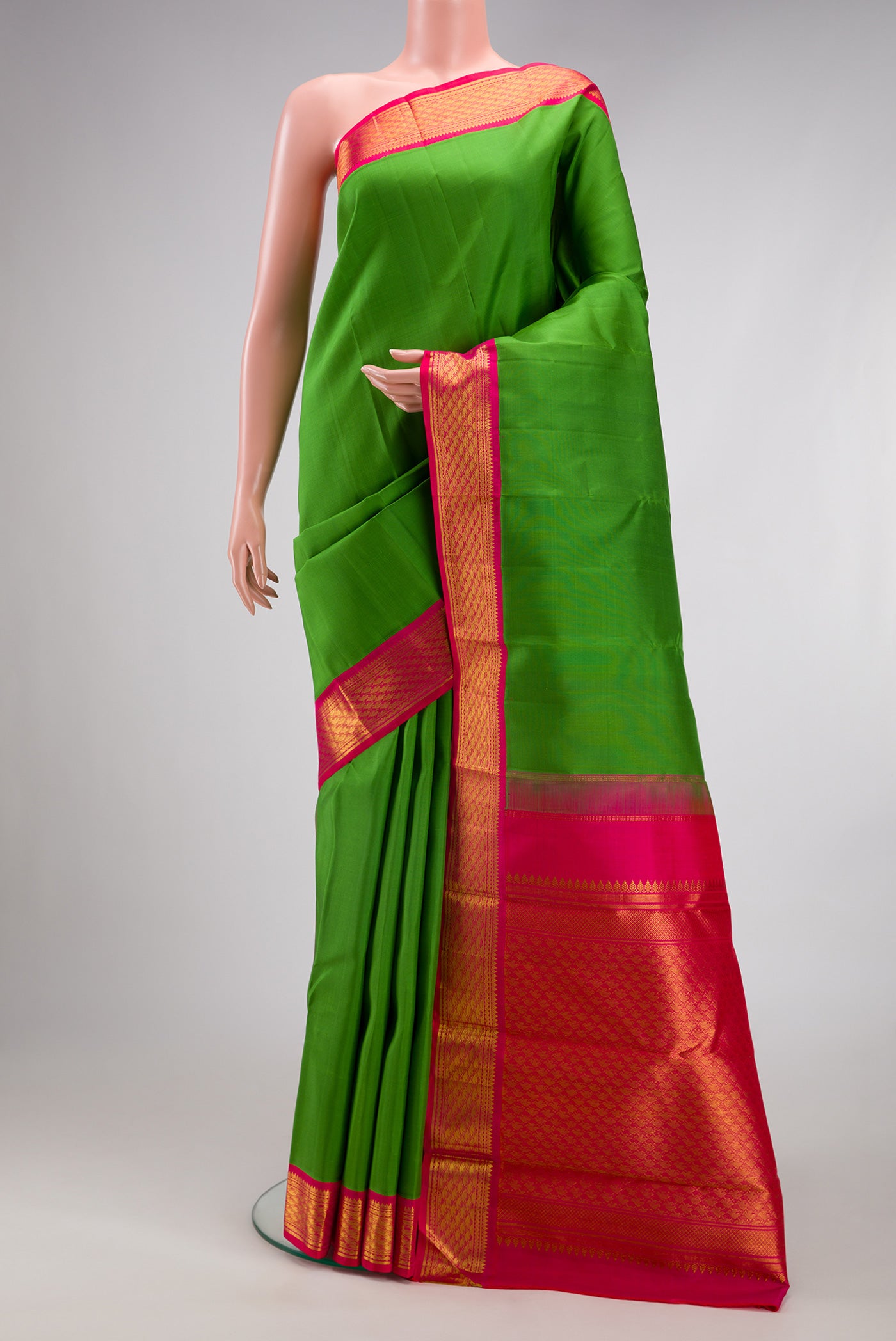 Green Kanjivaram Silk Saree with Plain Body and Zari Border.  displayed on a mannequin