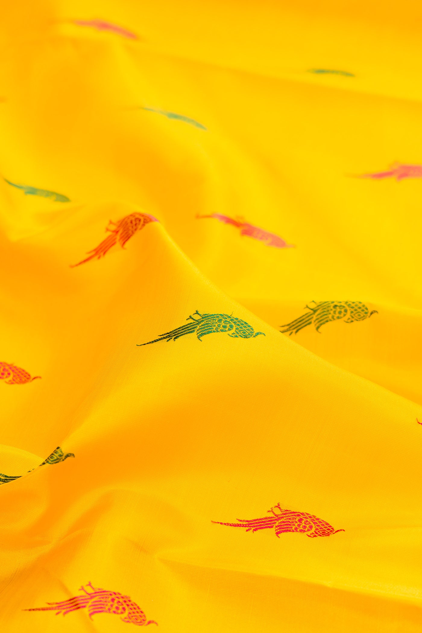 Close up of Yellow Kanjivaram Silk Saree with Thread Butta on the body and Fancy Border.  displaying folds