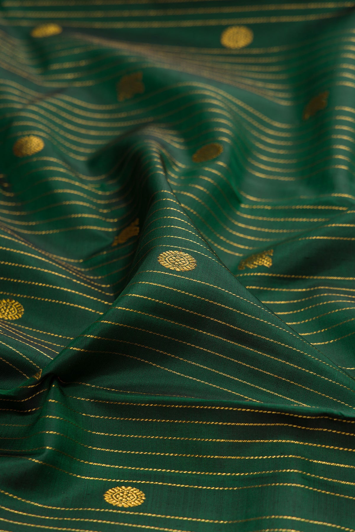 Close up of Bottle Green Kanjivaram Silk Saree with Stripes on the body and Fancy Border.  displaying folds