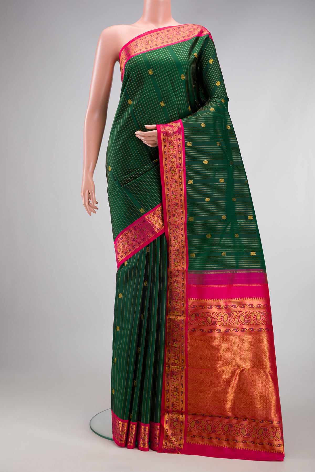 Bottle Green Kanjivaram Silk Saree with Stripes on the body and Fancy Border.  displayed on a mannequin