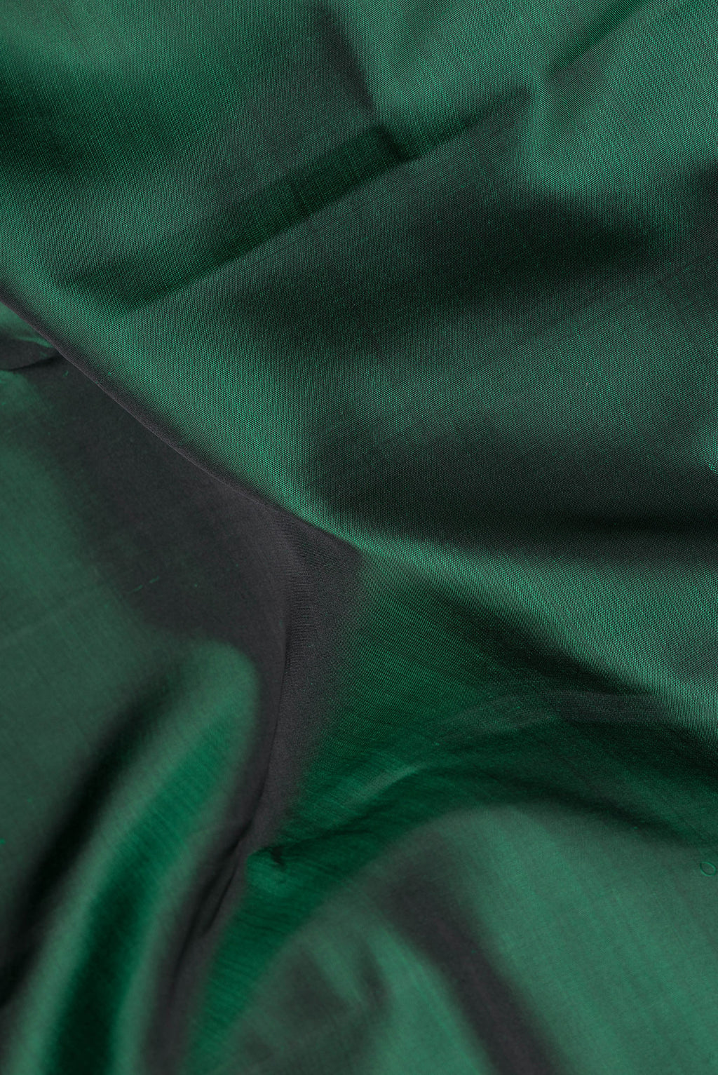 Close up of Pure Silk Bottle Green Kanchipuram Saree with Plain Body and Zari Border.  displaying folds