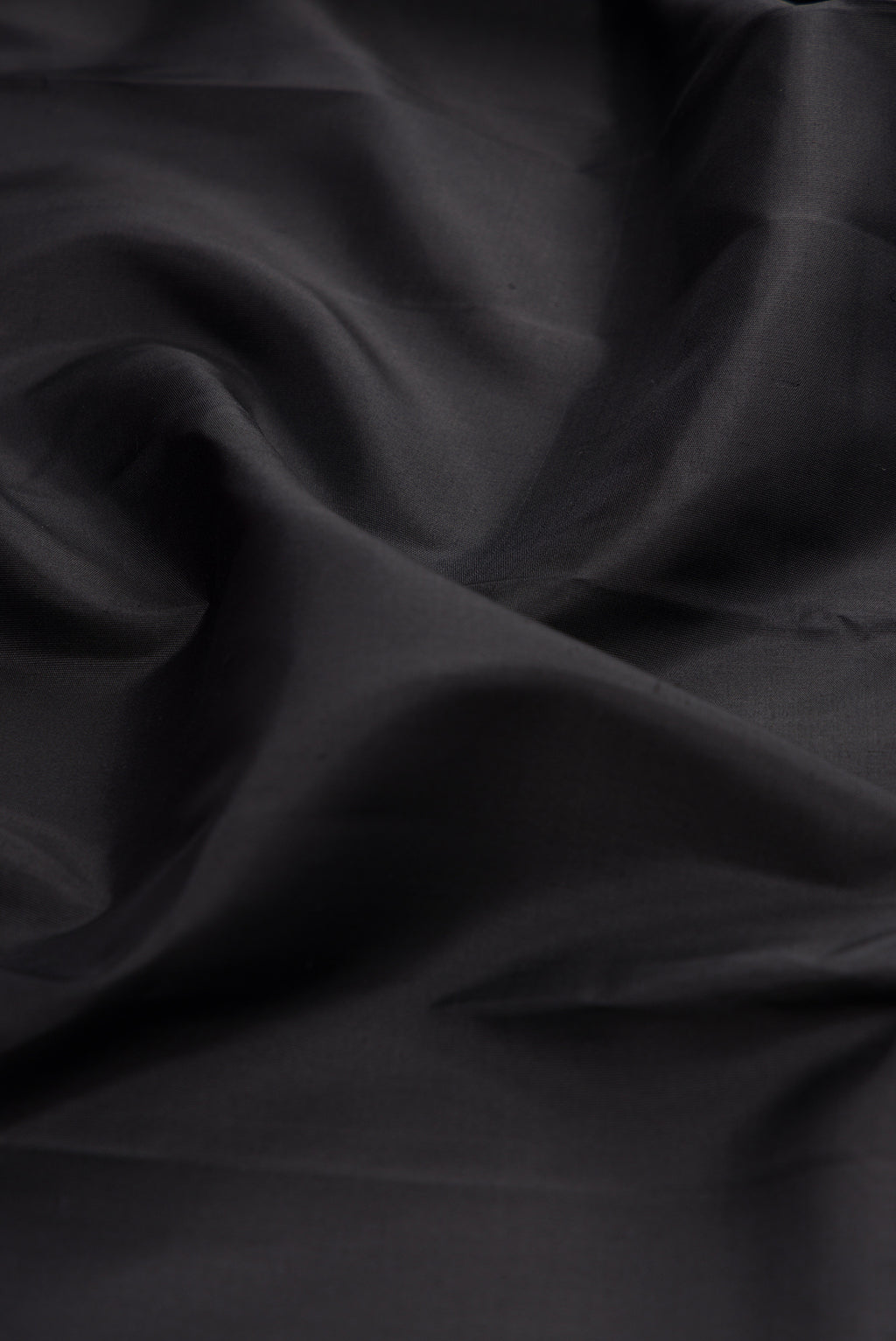 Close up of Black Kanchipuram Silk Saree with Plain Body and Zari Border.  displaying folds