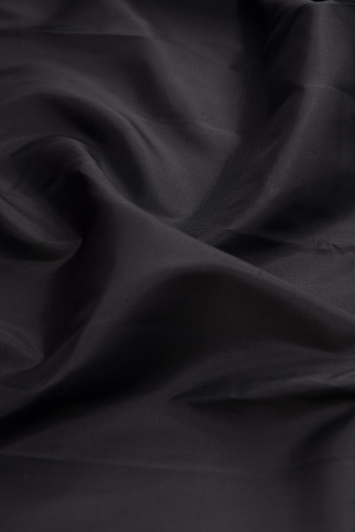 Close up of Black Kanchipuram Silk Saree with Plain Body and Zari Border.  displaying folds
