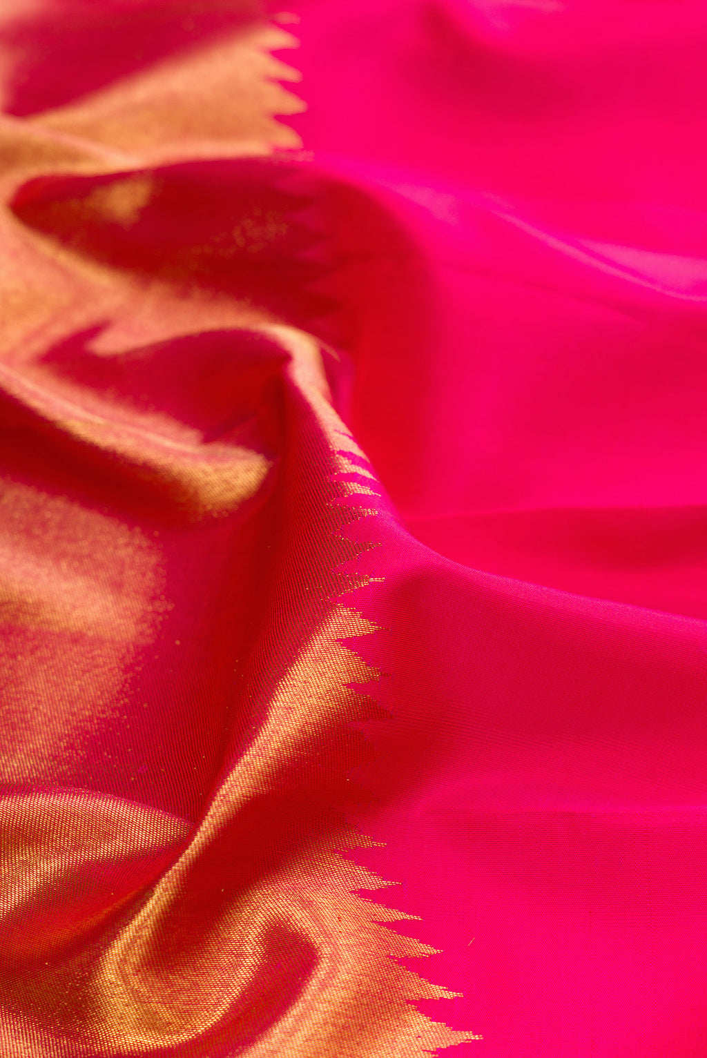 Close up of Pink Kanjivaram Silk Saree with Plain Body and Rising Temple Border.  displaying folds