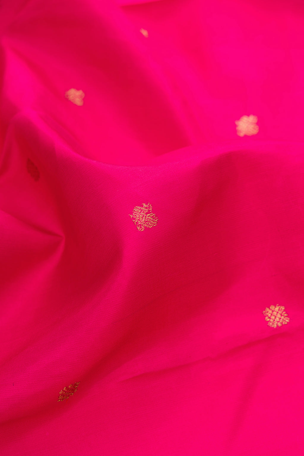 Close up of Pure Silk Pure Zari Pink Kanjivaram Saree with Zari Butta on the body and Fancy Border.  displaying folds