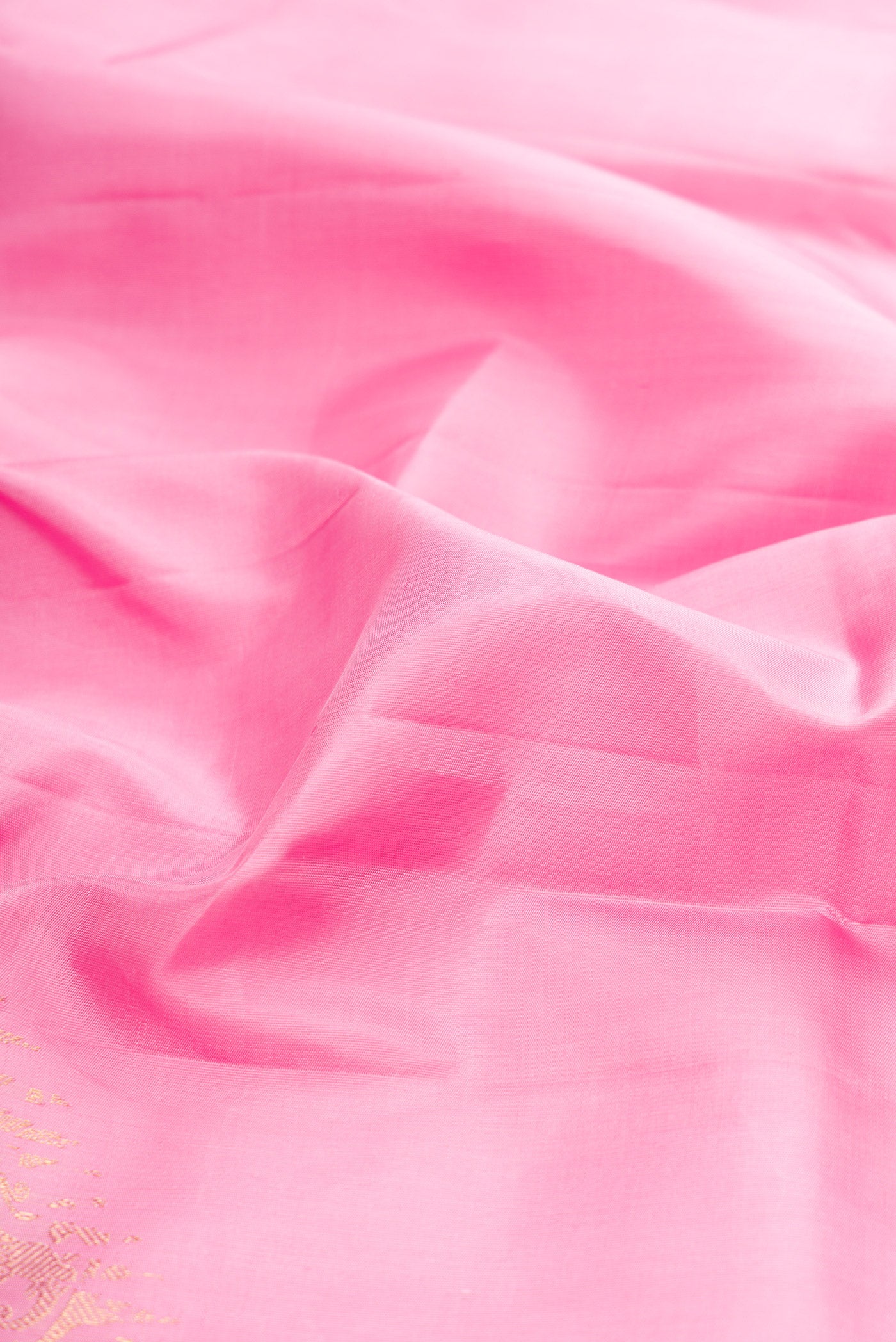 Close up of Pure Silk Pure Zari Rose pink Kanjivaram Saree with Plain Body and Fancy Border.  displaying folds