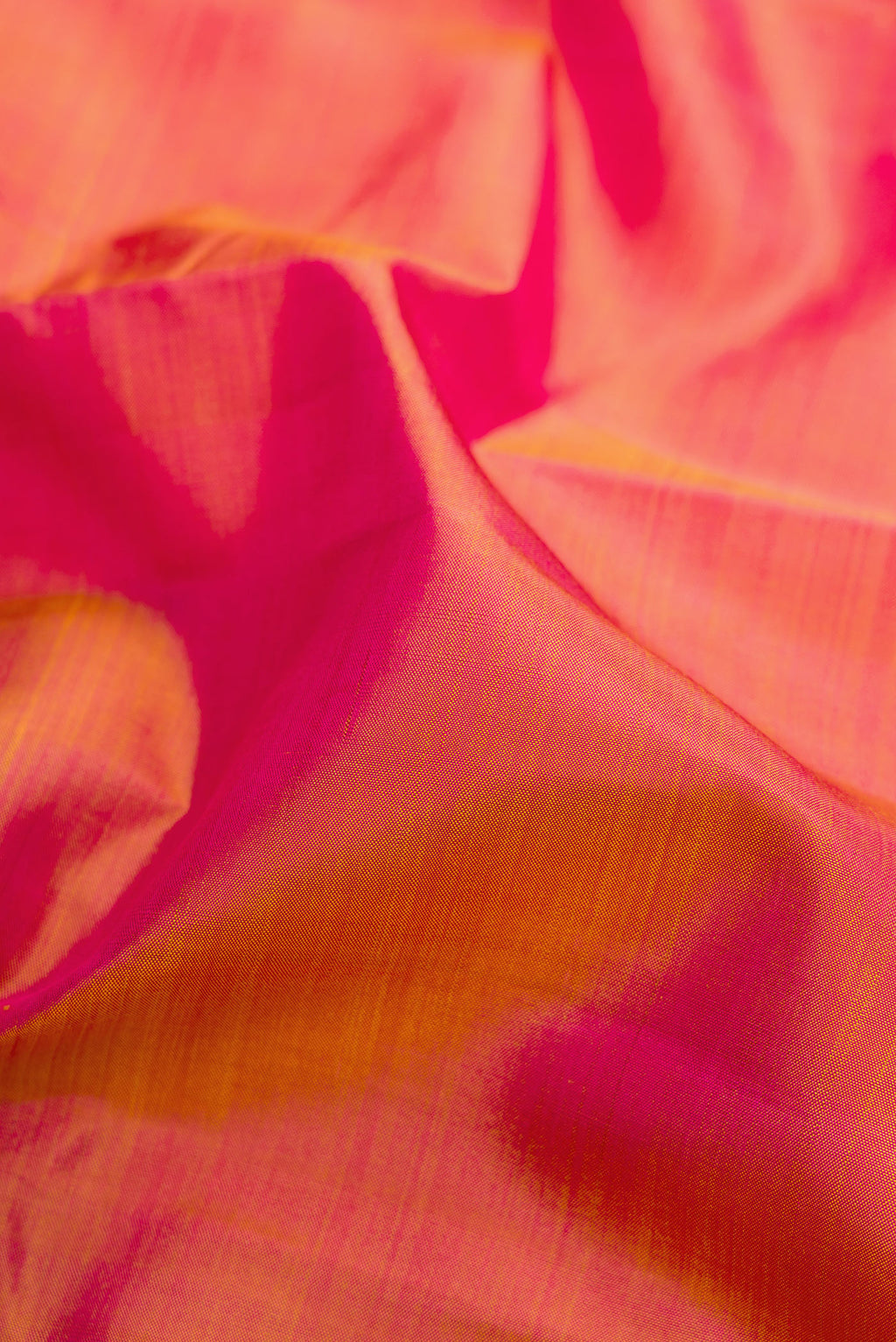 Close up of Pinkish Yellow Dual Tone Kanjivaram Silk Saree with Plain Body and Zari Border.  displaying folds