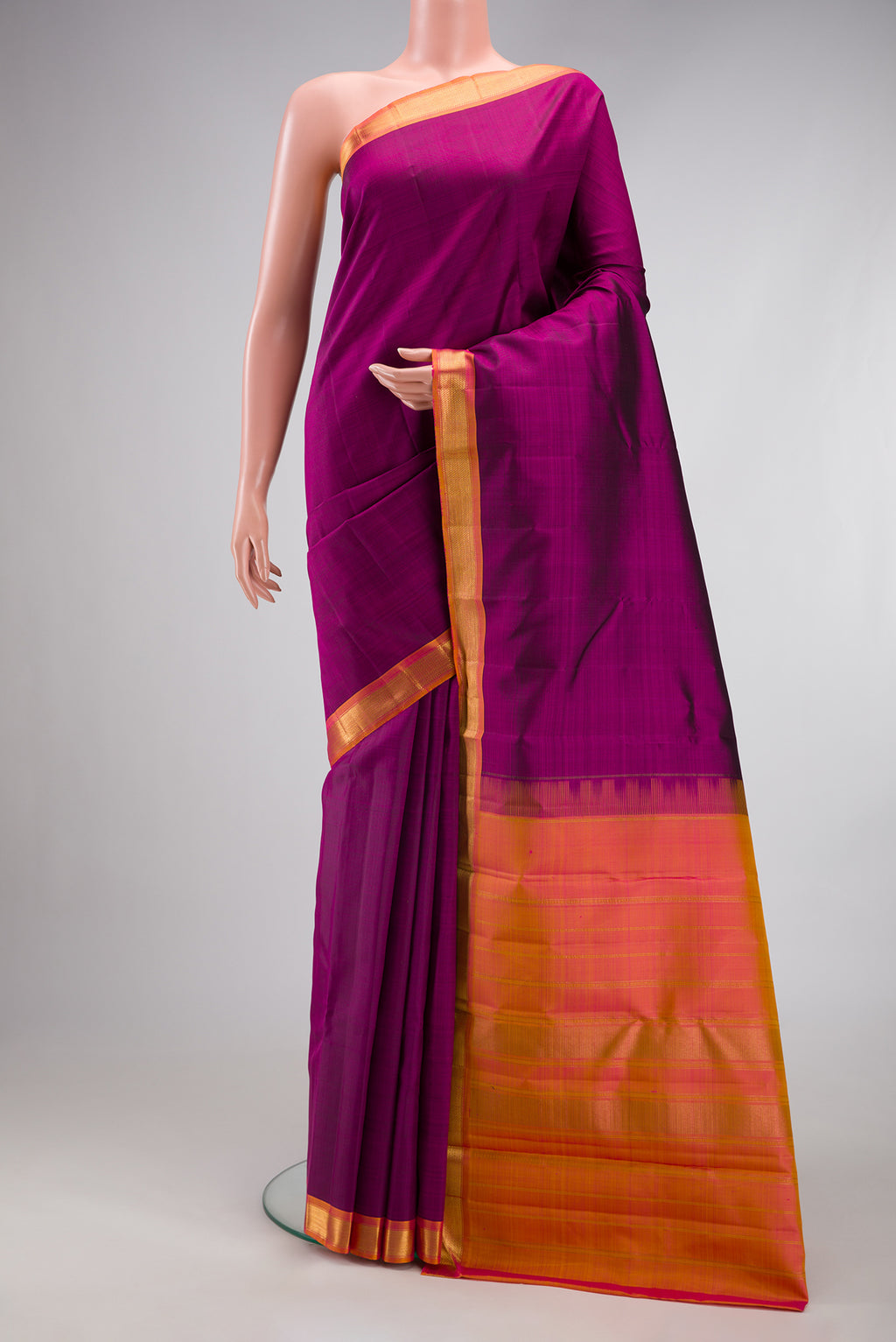 Magenta Kanjivaram Silk Saree with Plain Body and Zari Border.  displayed on a mannequin