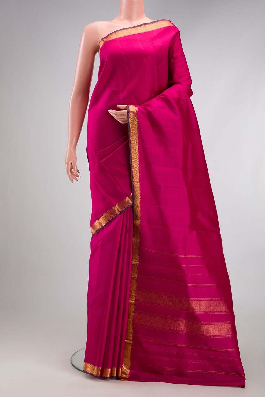 Rani Pink Kanjivaram Silk Saree with Plain Body and Zari Border.  displayed on a mannequin