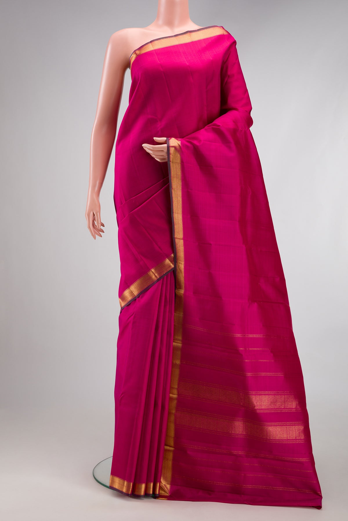 Rani Pink Kanjivaram Silk Saree with Plain Body and Zari Border.  displayed on a mannequin