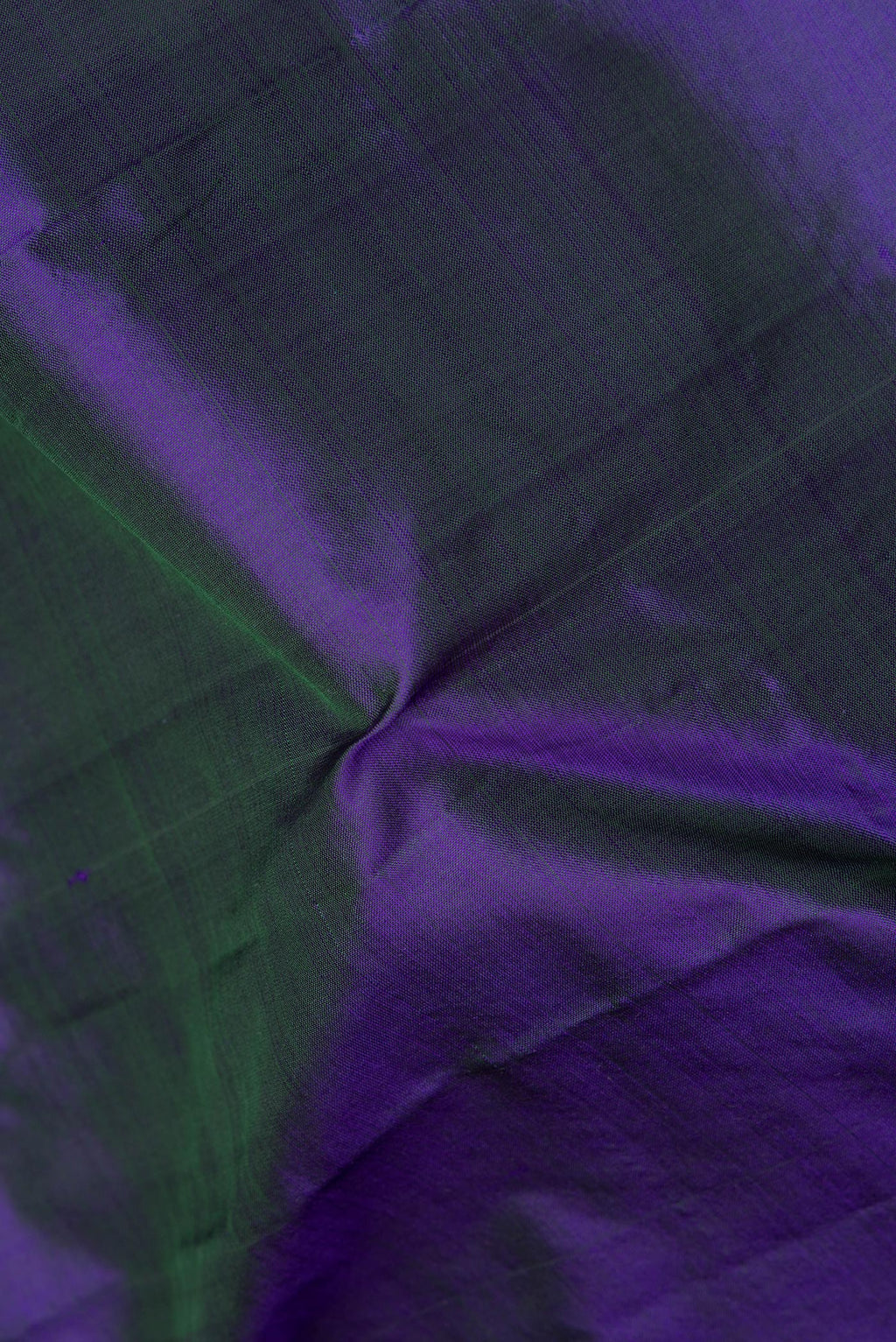 Close up of Pure Silk Peacock Blue Dual Tone Kanchipuram Saree with Plain Body and Zari Border.  displaying folds