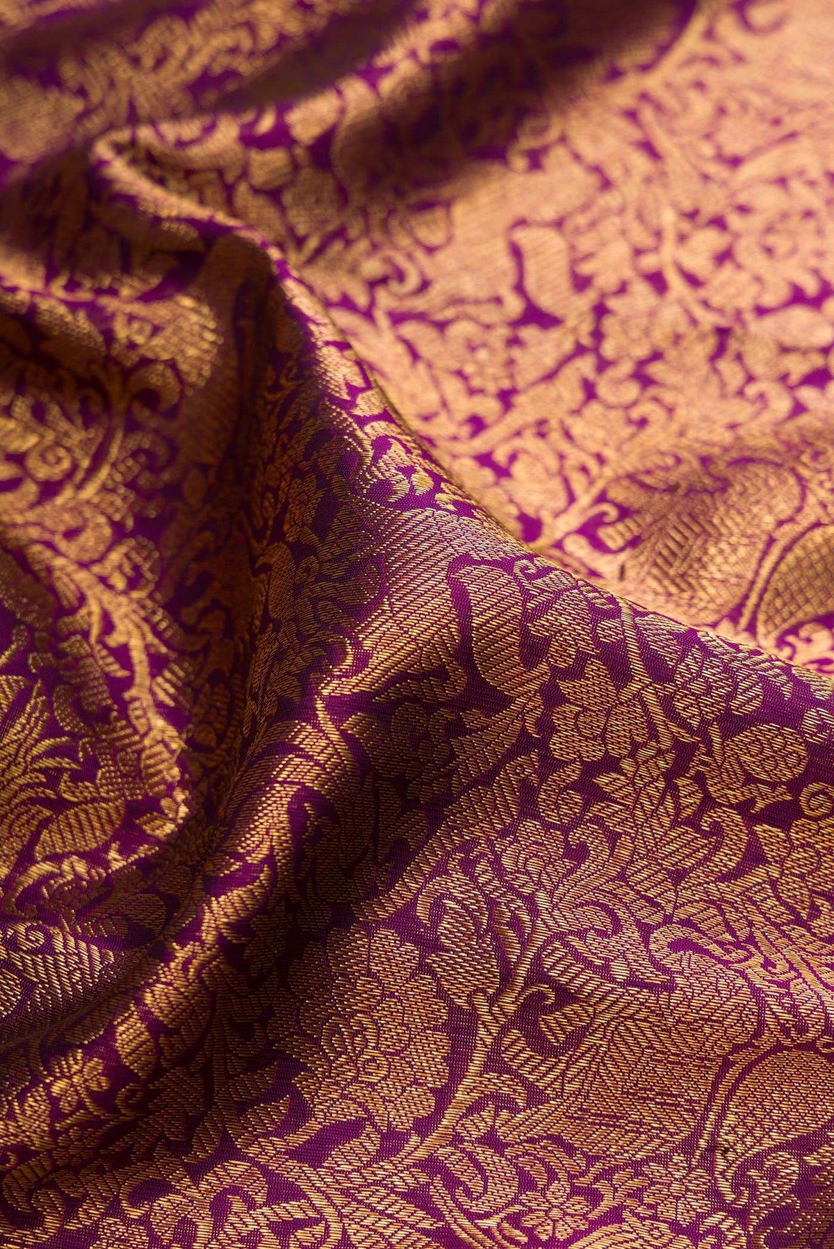 Close up of Pure Silk Pure Zari Purple Kanjivaram Saree with Zari Brocade on the body and Zari Border.  displaying folds