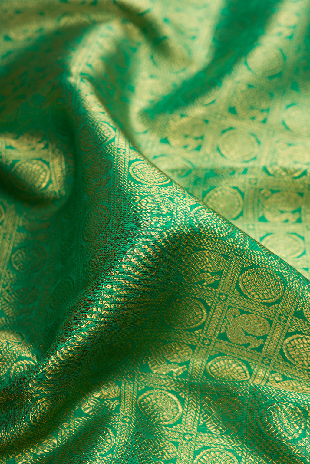 Close up of Pure Silk Pure Zari Green Kanjivaram Saree with Zari Brocade on the body and Zari Border.  displaying folds