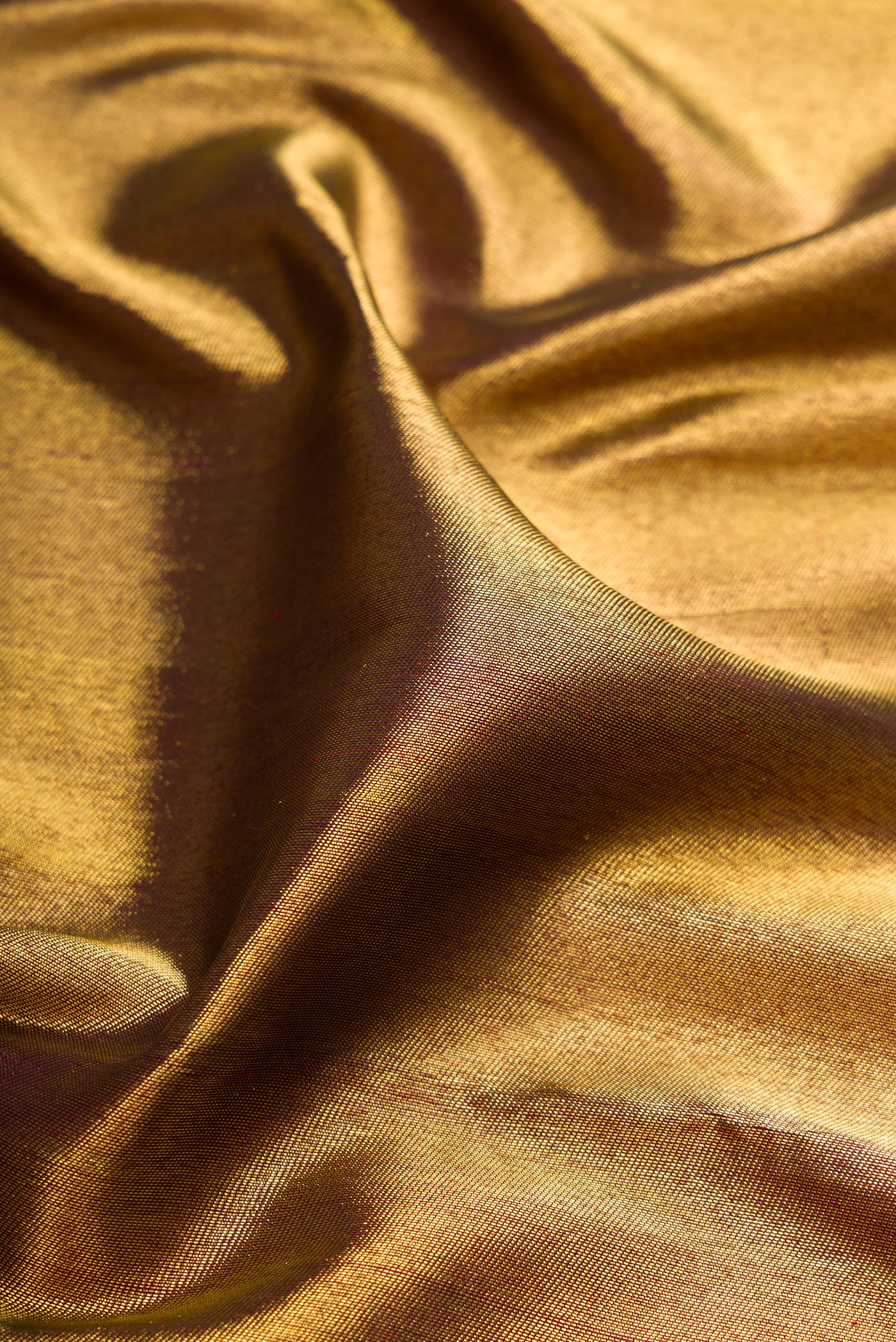 Close up of Maroon Dual Tone Kanjivaram Silk Saree with Zari Brocade on the body and Zari Border.  displaying folds