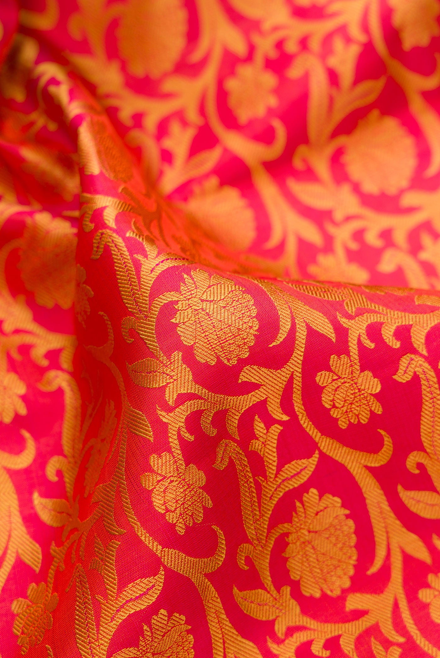 Close up of Pure Silk Pure Zari Orange Kanjivaram Saree with Jacquard design on the body and Zari And Thread Border.  displaying folds