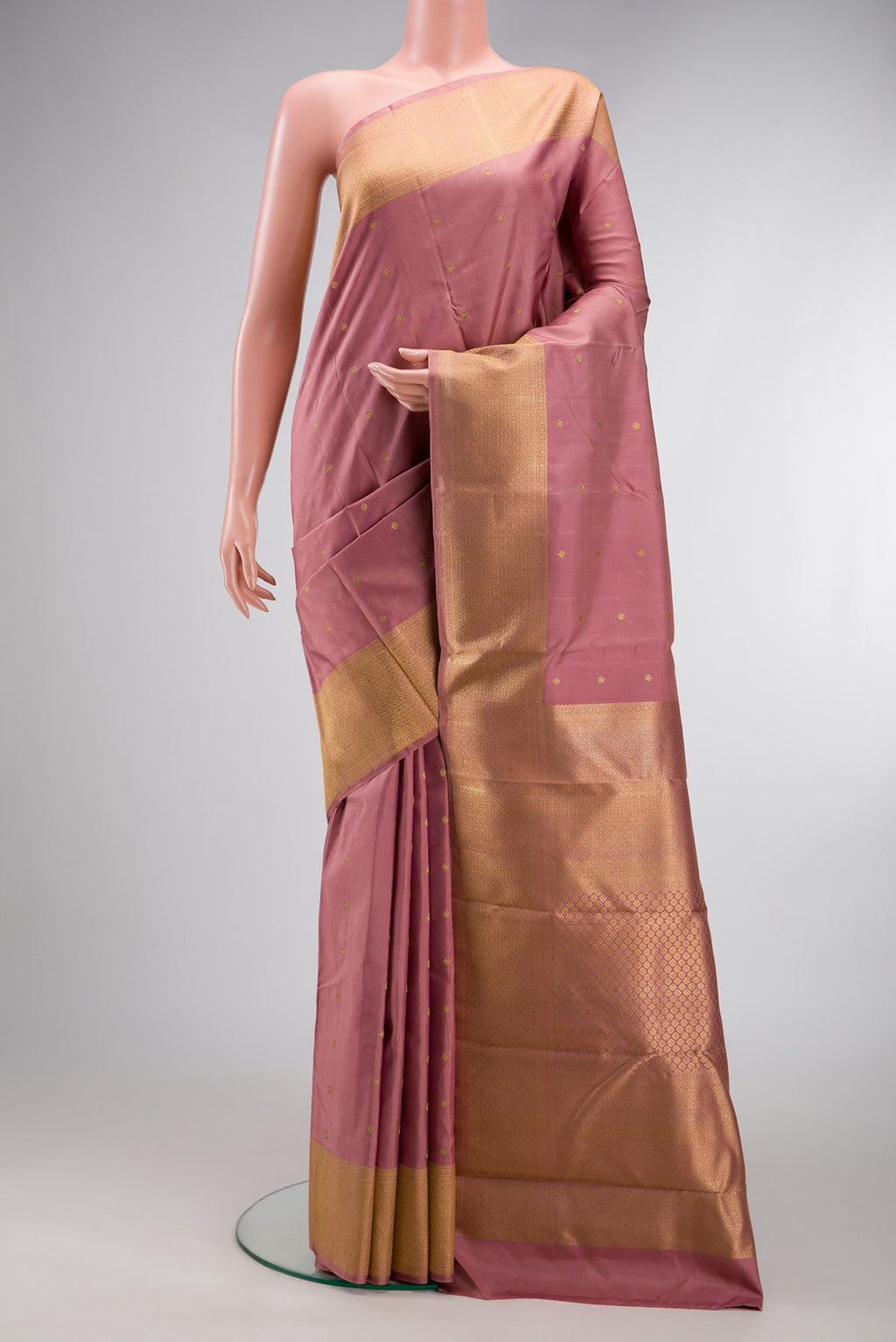 Pure Silk Pure Zari Rose Gold Kanjivaram Saree with Zari Butta on the body and Zari Border.  displayed on a mannequin