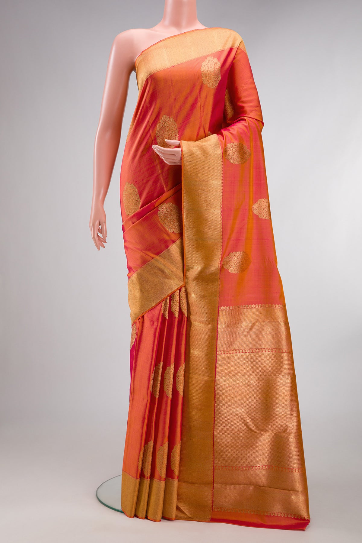 Pure Silk Pure Zari Brick Orange Dual Tone Kanjivaram Saree with Zari Butta on the body and Zari Border.  displayed on a mannequin
