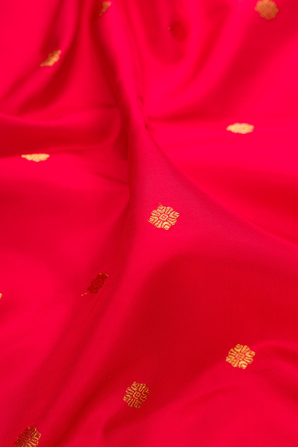 Close up of Pure Silk Pure Zari Red Kanjivaram Saree with Zari Butta on the body and Fancy Border.  displaying folds